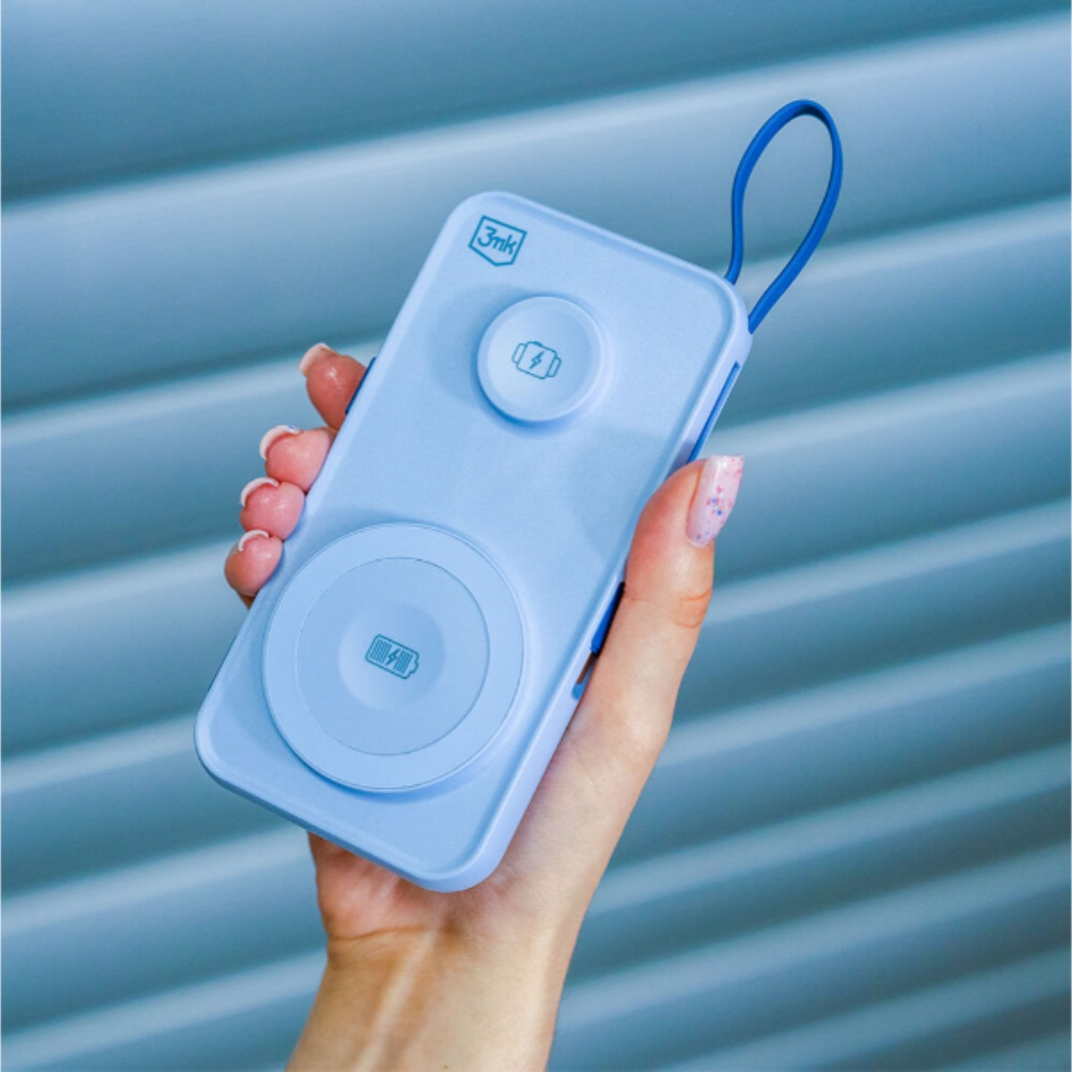 Ręka trzymająca niebieską podkładkę ładującą.