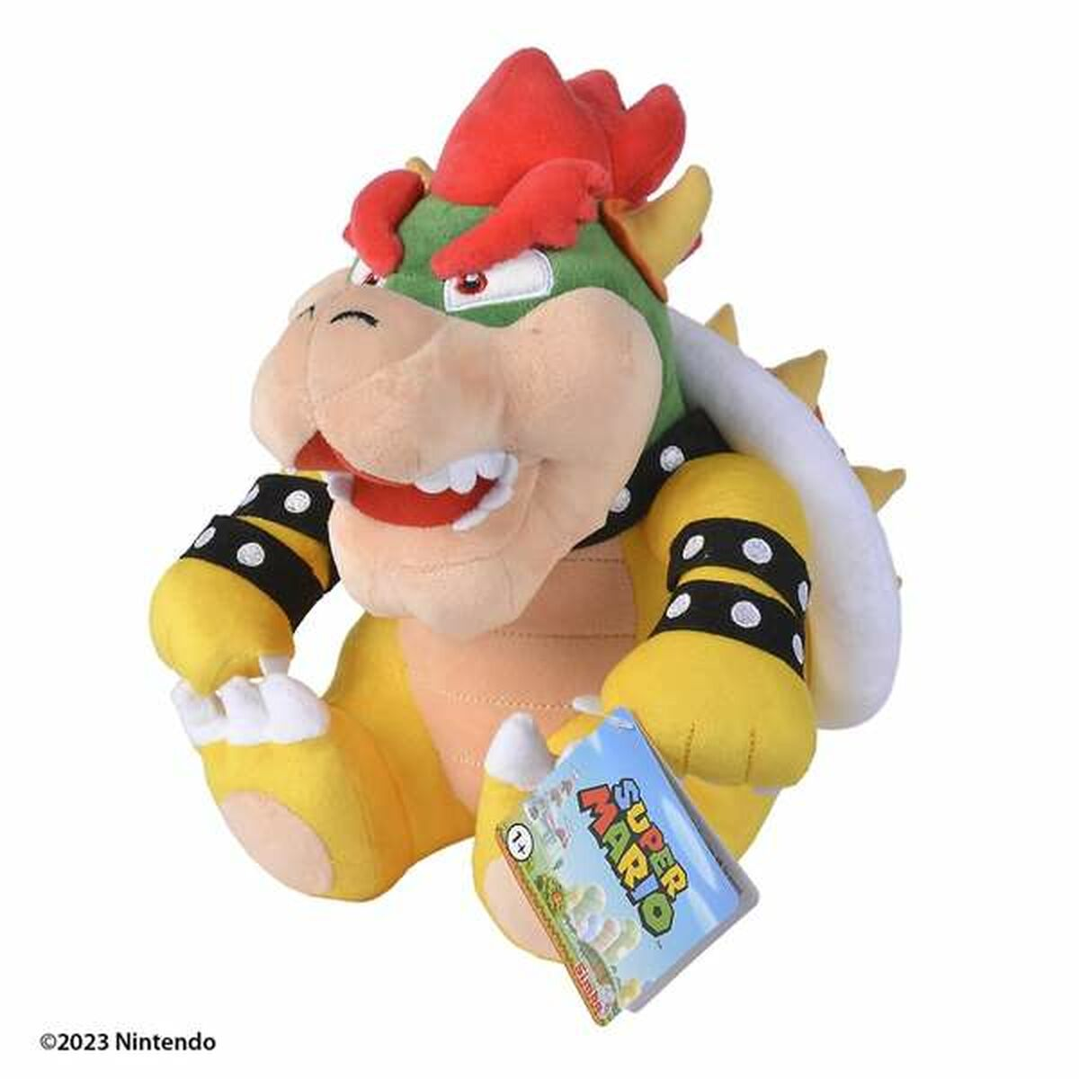 Peluche di Bowser con guscio rosso, corpo verde e pancia gialla. C'è un'etichetta allegata.