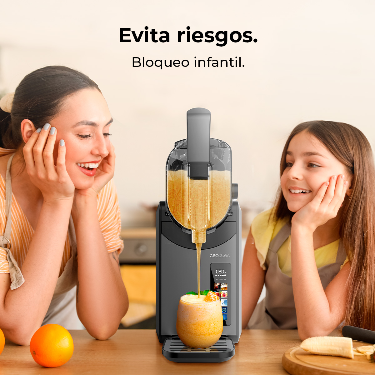 Una donna e una bambina guardano un estrattore di succo con un bicchiere di succo versato.