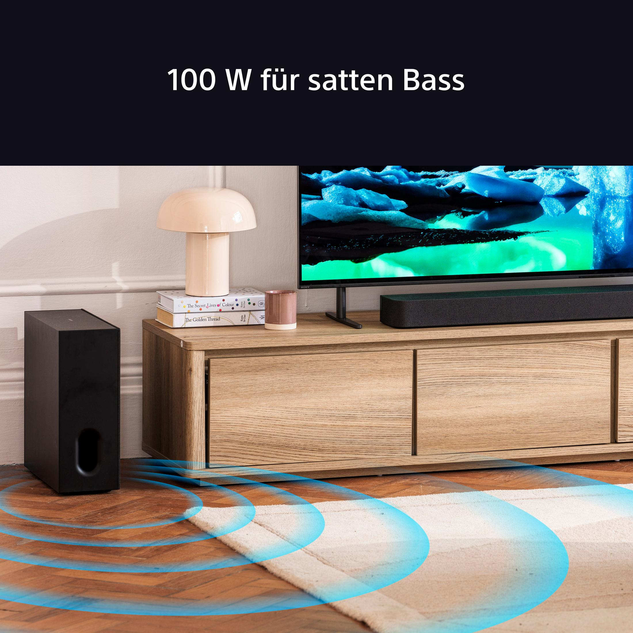 Wohnzimmer mit TV und Subwoofer. Holzschrank, Lampe, Bücher. Blaue Schallwellen vom Subwoofer ausgehend.