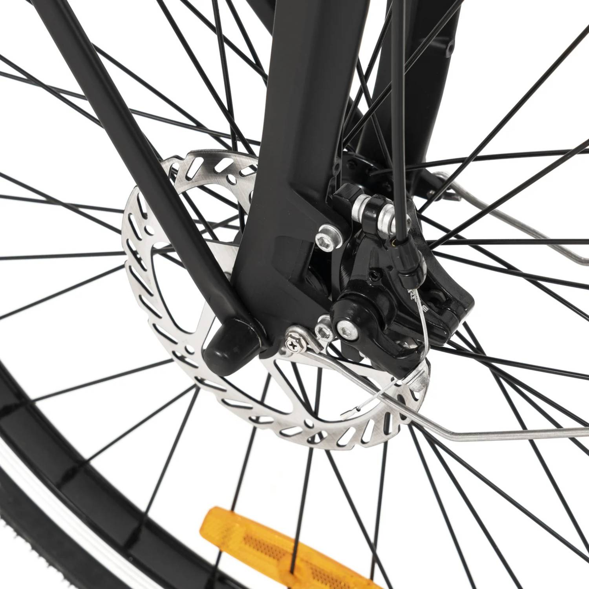 Zbliżenie przedniego koła roweru. Ostrość na hamulcu tarczowym, czarnym widelcu i szprychach.