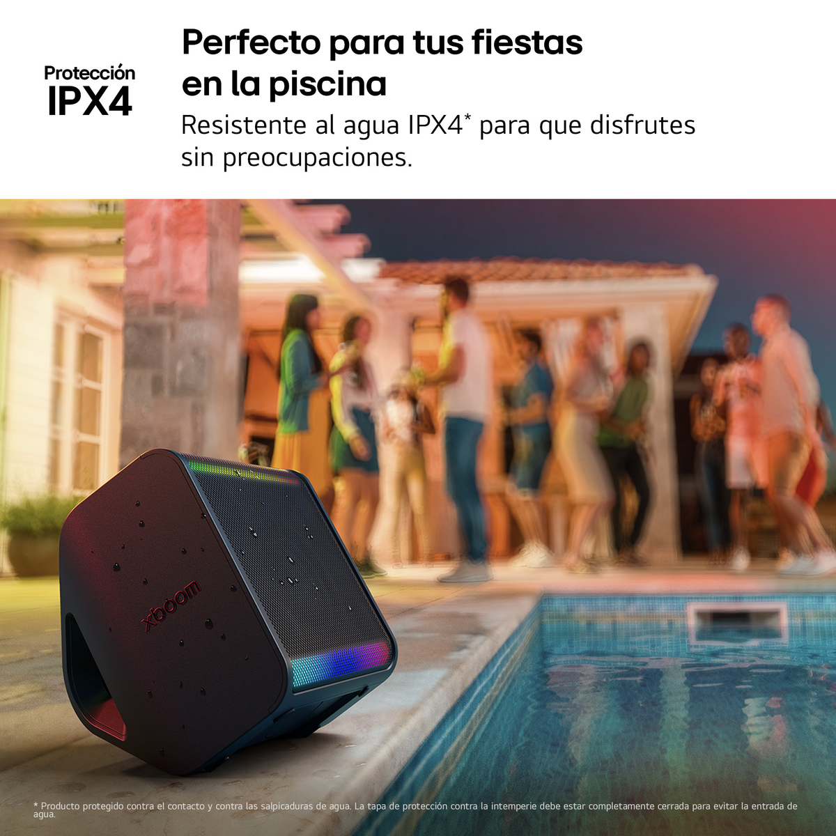 Altavoz negro tocando junto a una piscina, con gente al fondo, ambiente crepuscular.