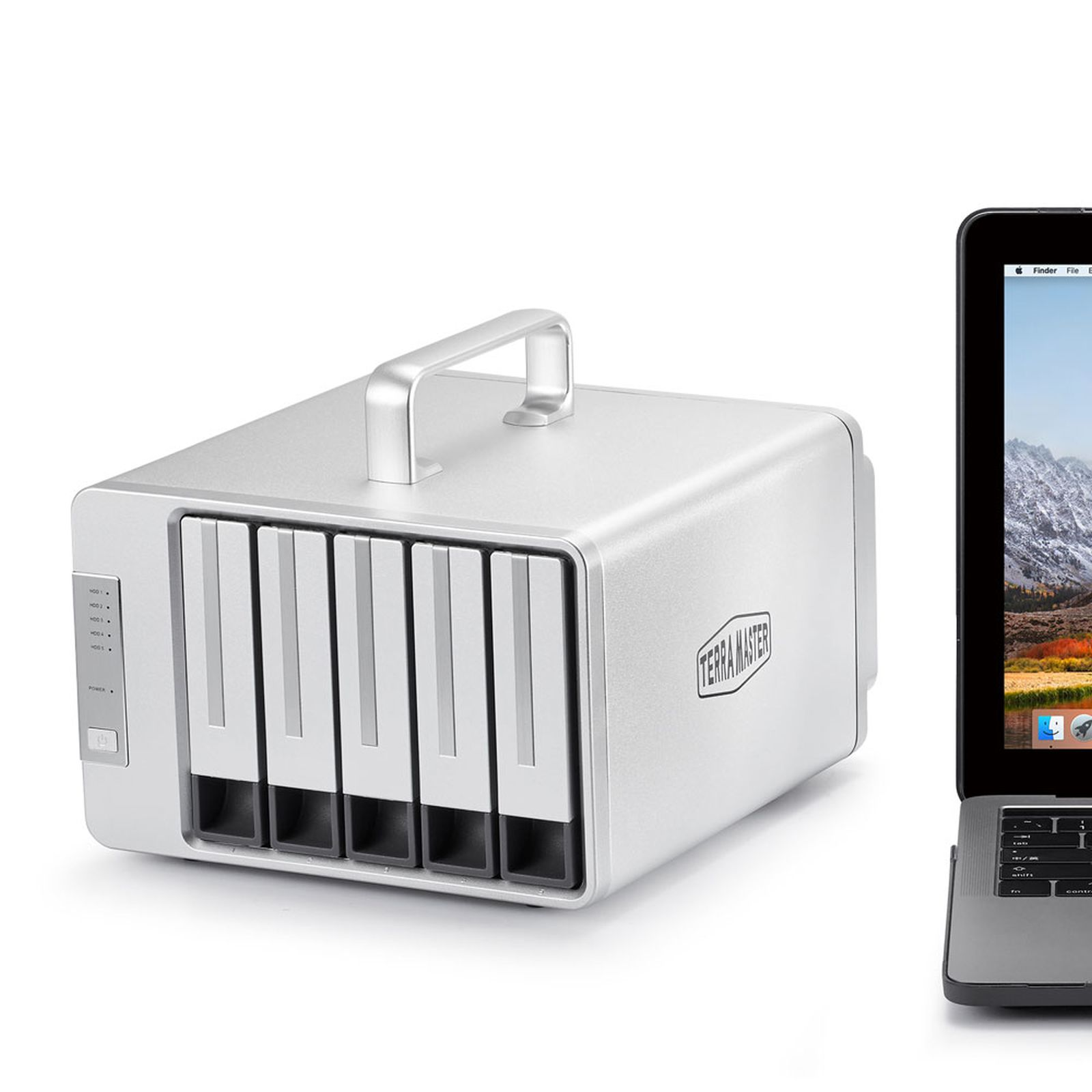 Hard disk esterno argentato accanto a un laptop. Il laptop mostra una scena di montagna.