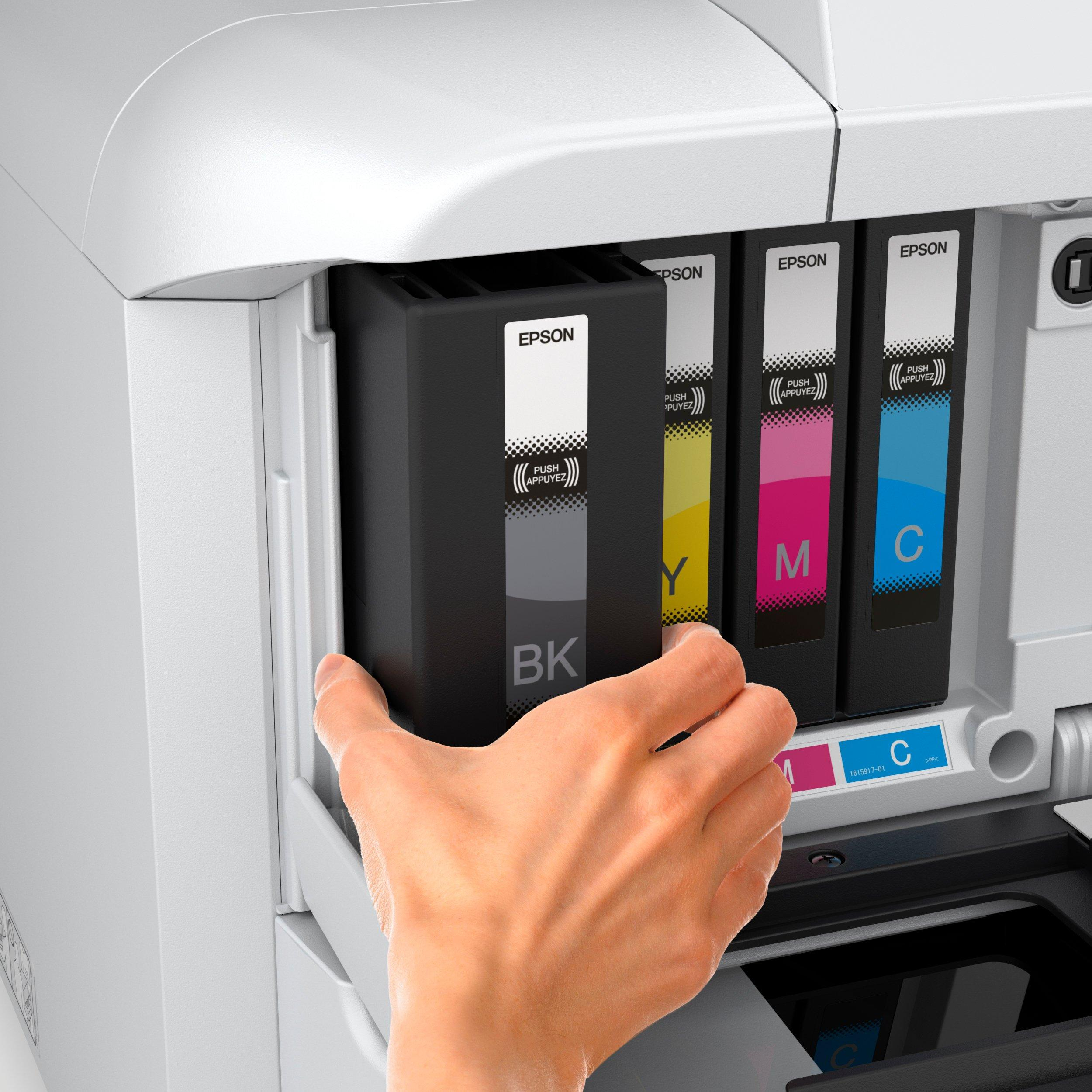Ręka wkłada czarne, żółte, purpurowe i cyjanowe wkłady atramentowe do białej drukarki Epson.