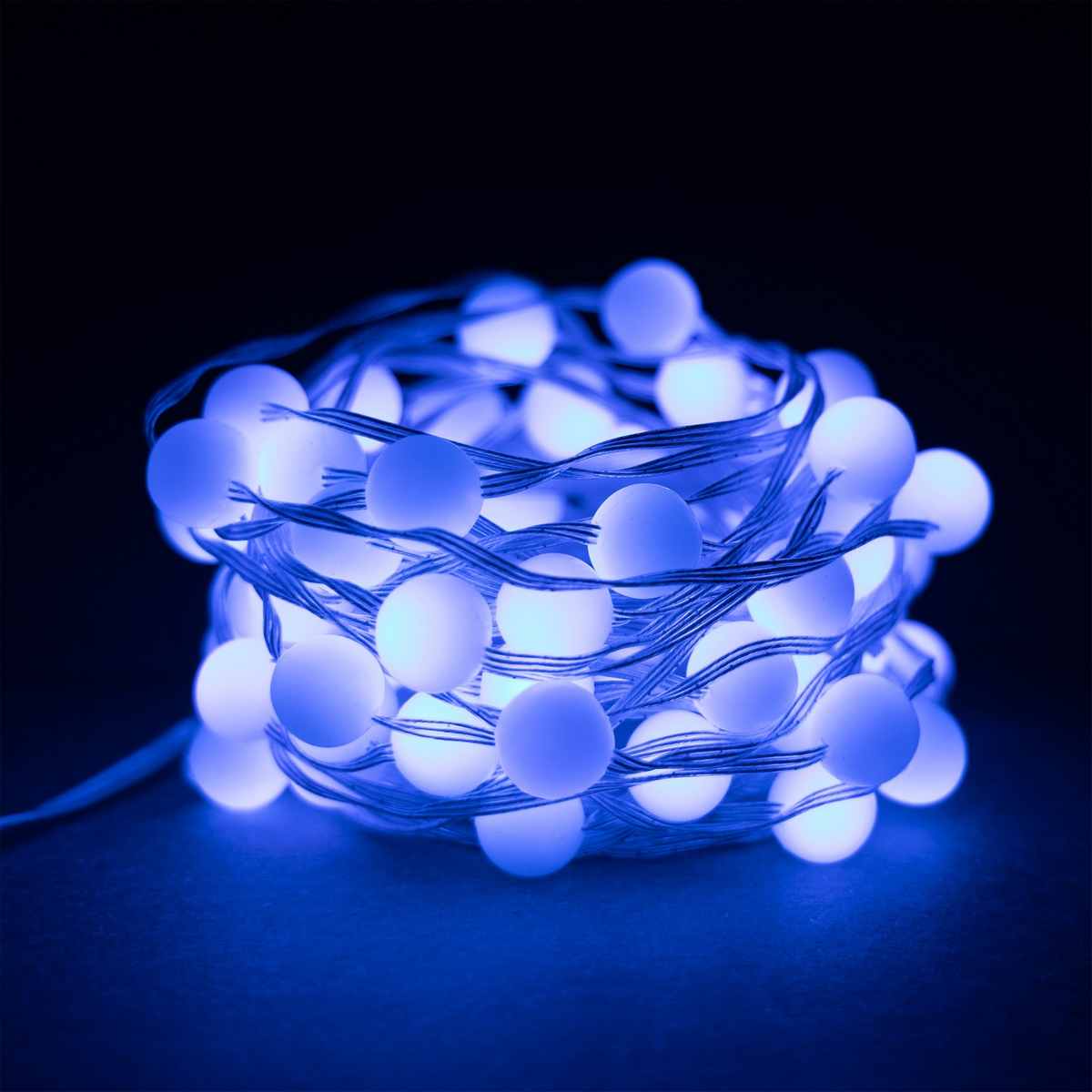 Una stringa di luci LED blu avvolta su una superficie scura. Le luci sono molto vicine tra loro.