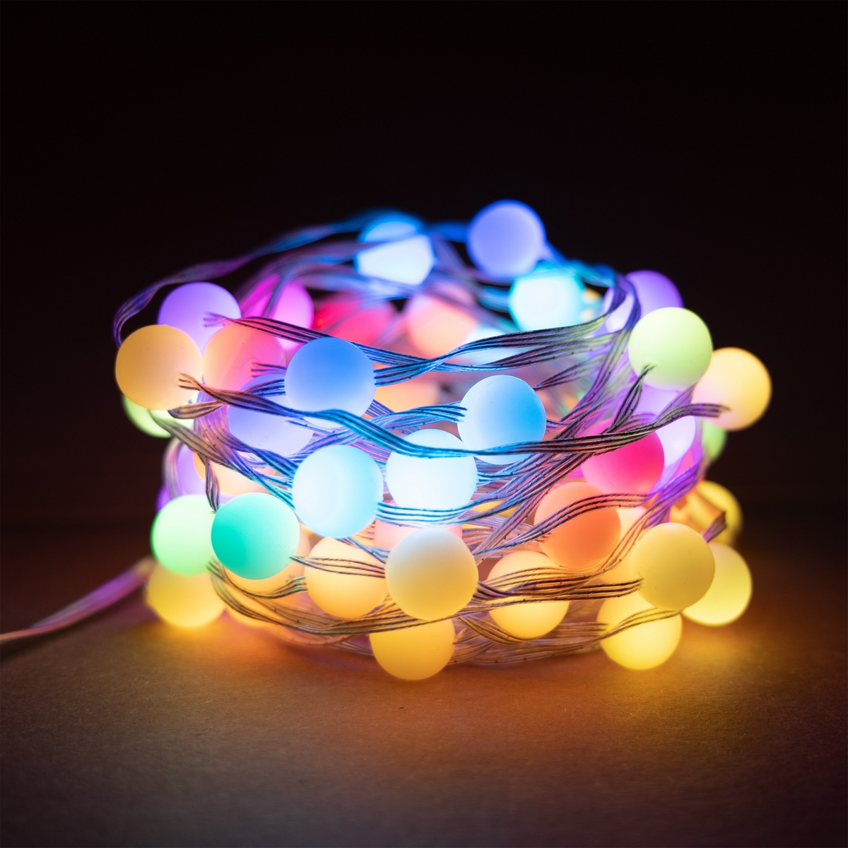 Una stringa di luci LED avvolta con lampadine multicolori, su uno sfondo scuro.