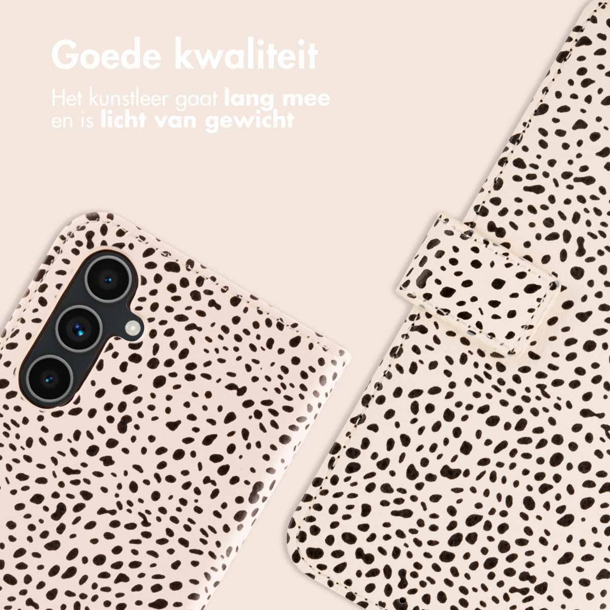 Coque de téléphone à pois noirs sur fond blanc. Le téléphone a trois caméras.