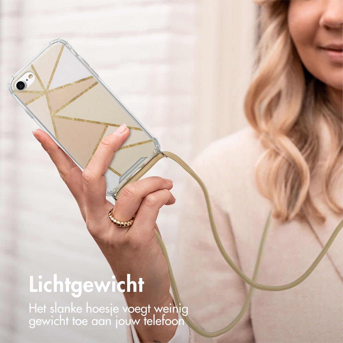 Une femme tient un téléphone avec une coque à motifs géométriques et une sangle beige. Le téléphone est léger.