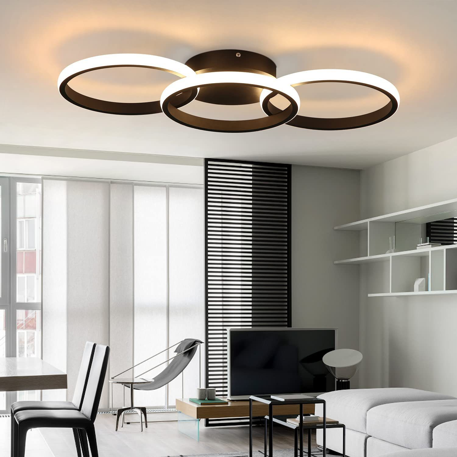 Nowoczesny salon z dużą lampą sufitową, sofą, stołem i krzesłami. Jasna, neutralna kolorystyka.