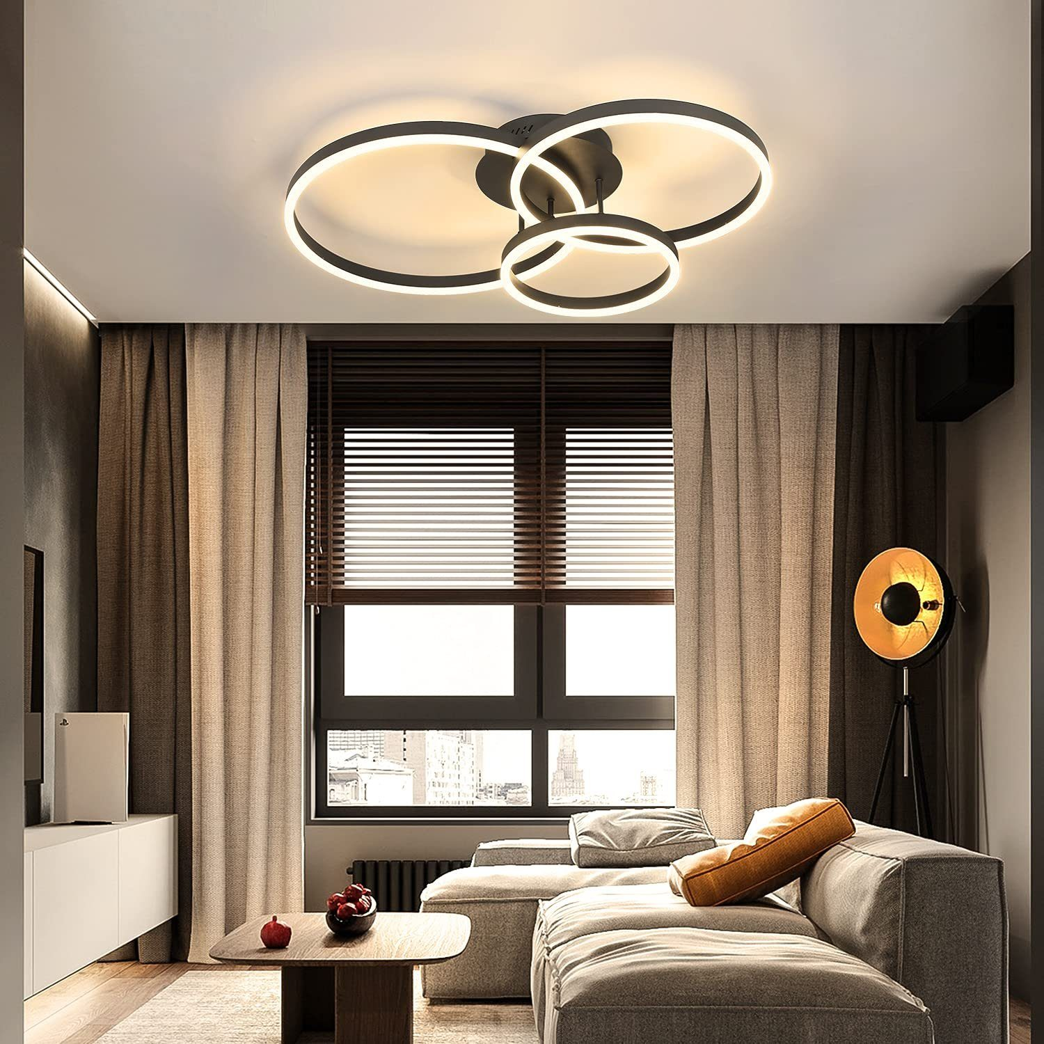Wohnzimmer mit schwarzer Deckenleuchte. Sofa, Vorhänge und Fenster. Ein Couchtisch mit einer Pflanze.