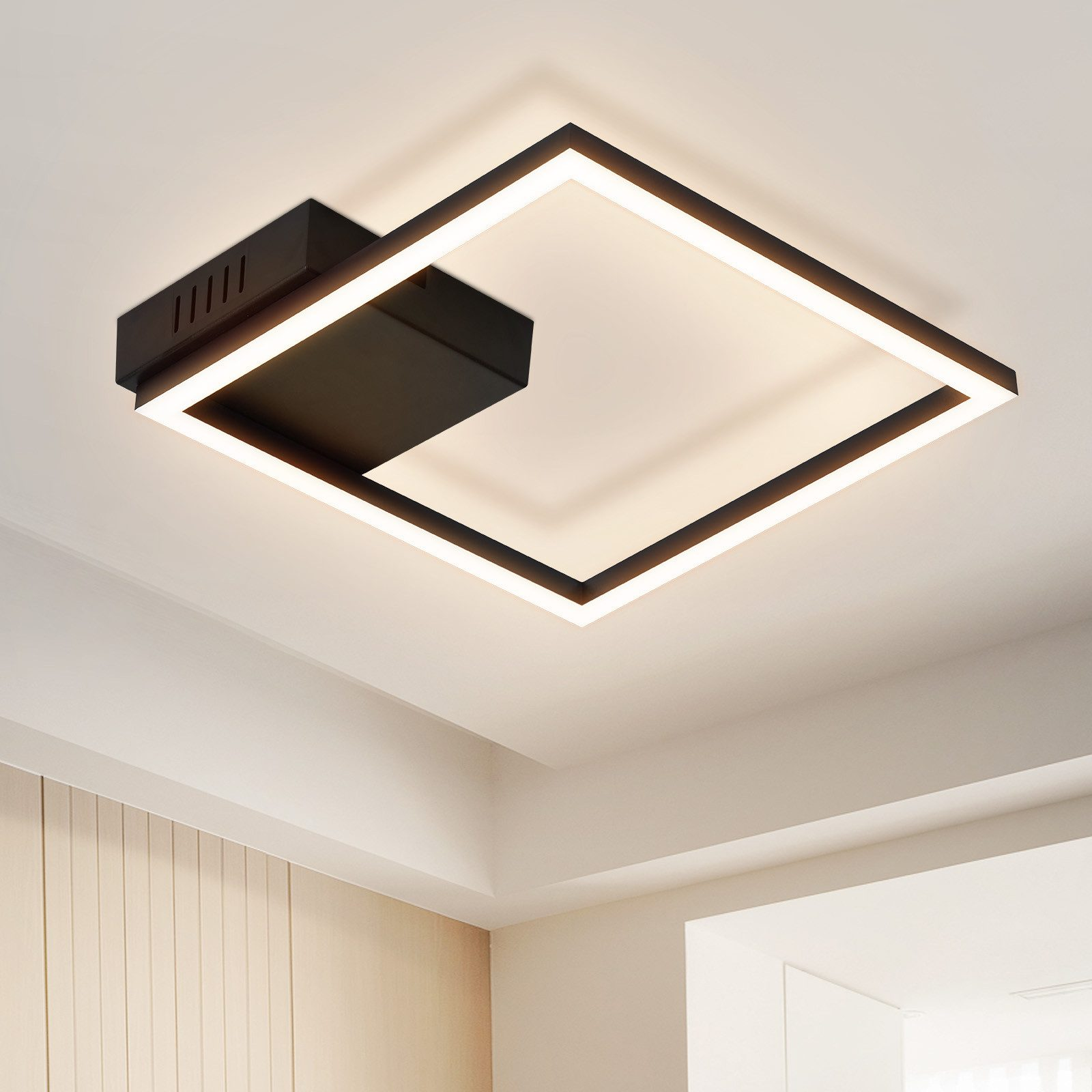 Plafoniera quadrata, cornice nera con centro bianco ed elemento nero sfalsato. Soffitto bianco.