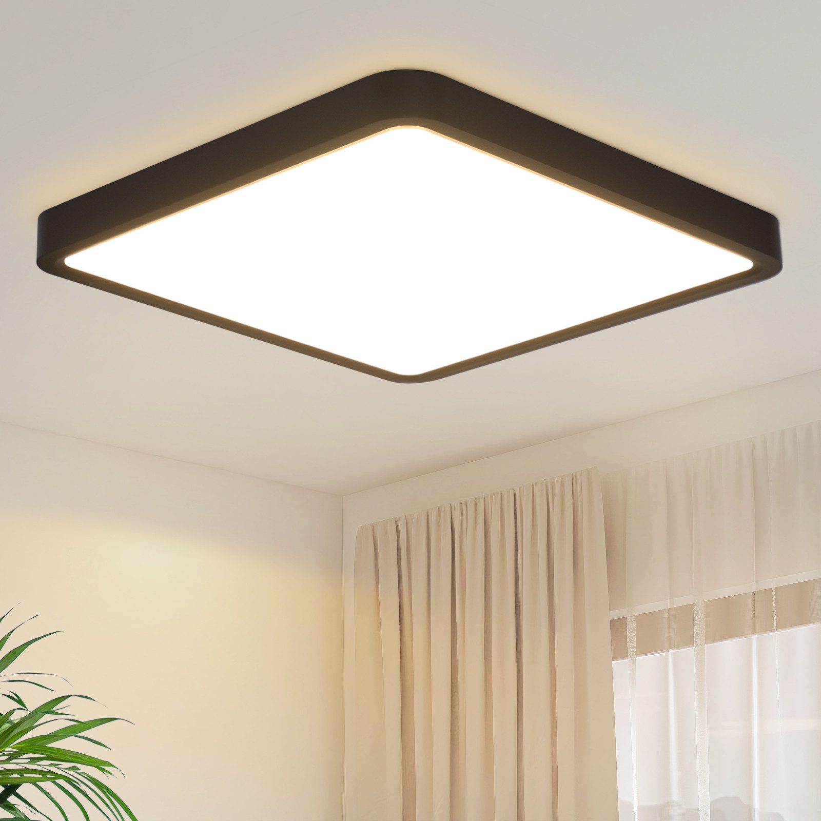 Una plafoniera quadrata con cornice nera, posta contro un soffitto bianco, accanto a tende.