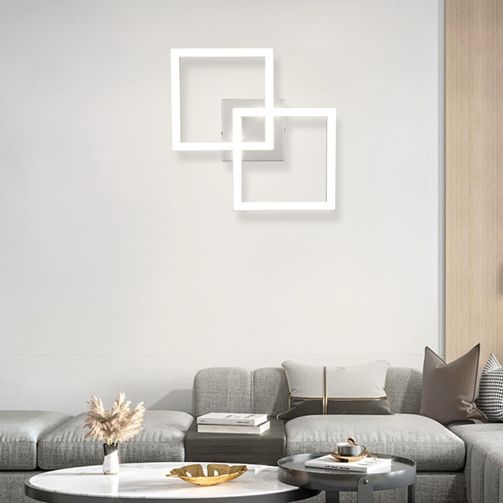 Luces cuadradas blancas en una pared, con sofá y decoración debajo.