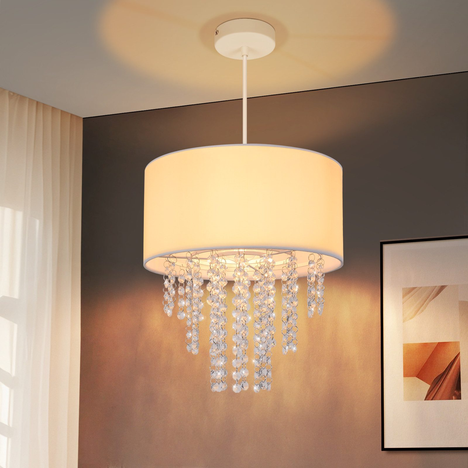 Eine weiße Deckenlampe mit Stoffschirm und hängenden Kristallperlen, die in einem Raum hängt.