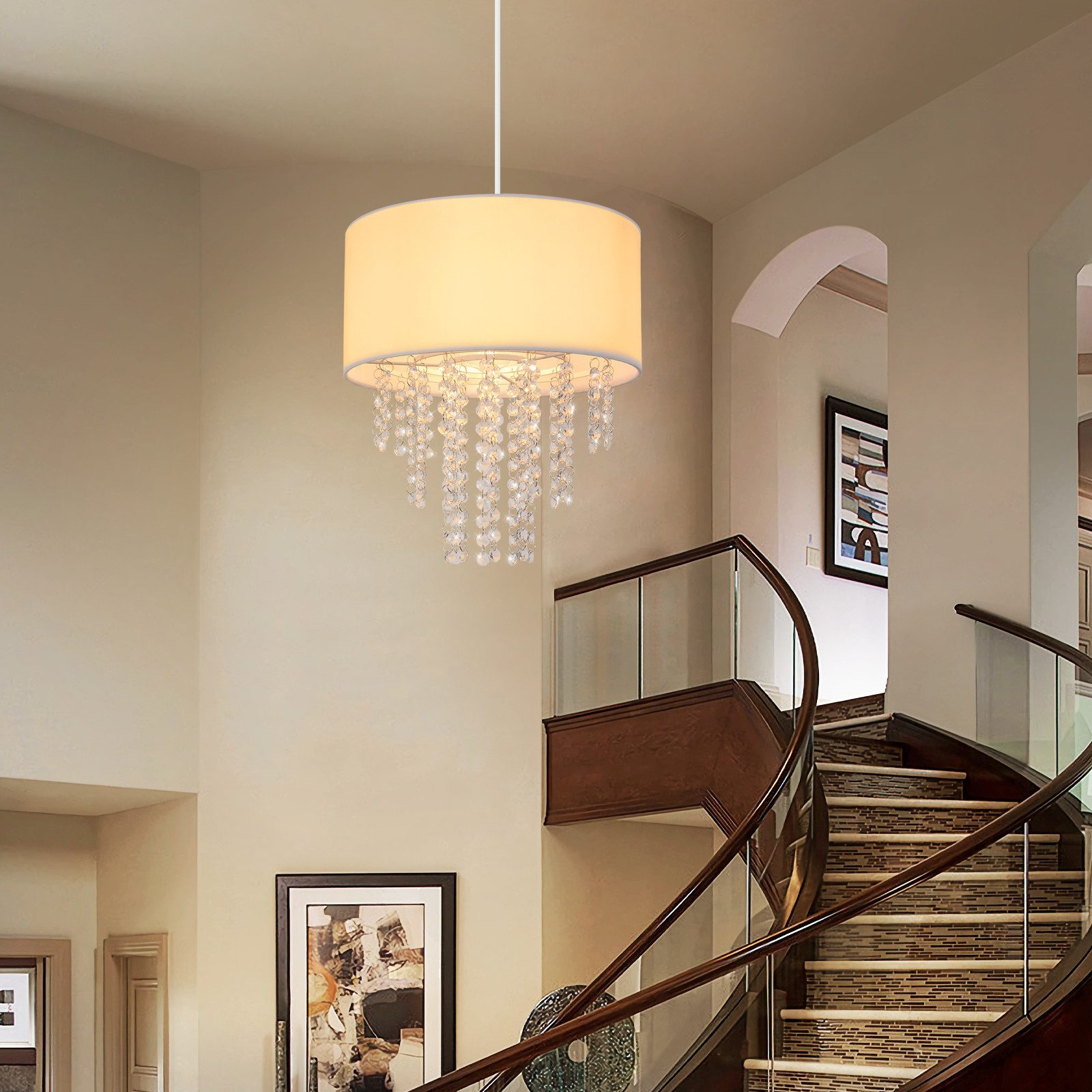 Eine weiße Deckenlampe mit Stoffschirm und Kristallperlen, die in einem Raum mit Treppe hängt.