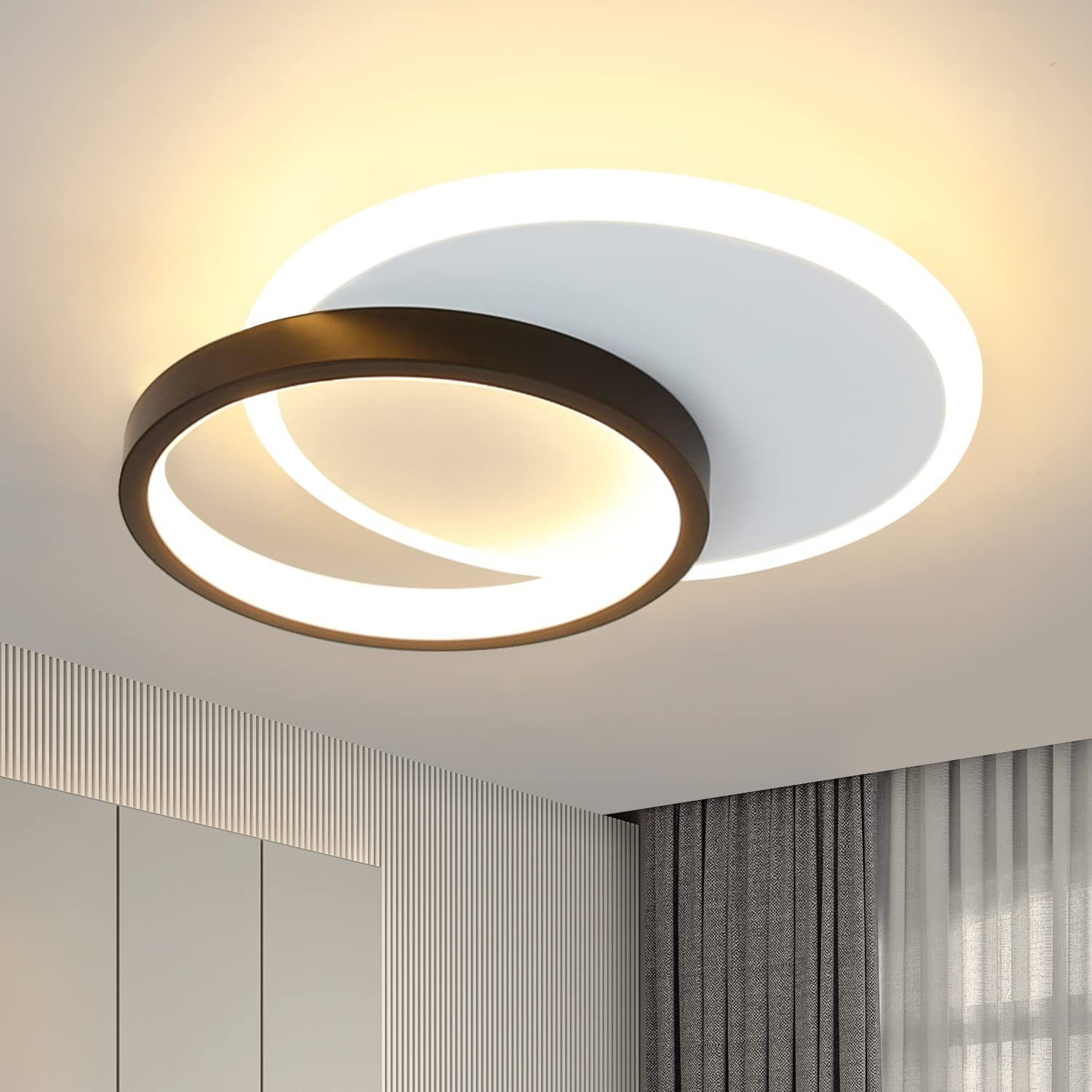 Una moderna lámpara de techo con un diseño blanco y negro. Es circular y tiene una luz brillante.