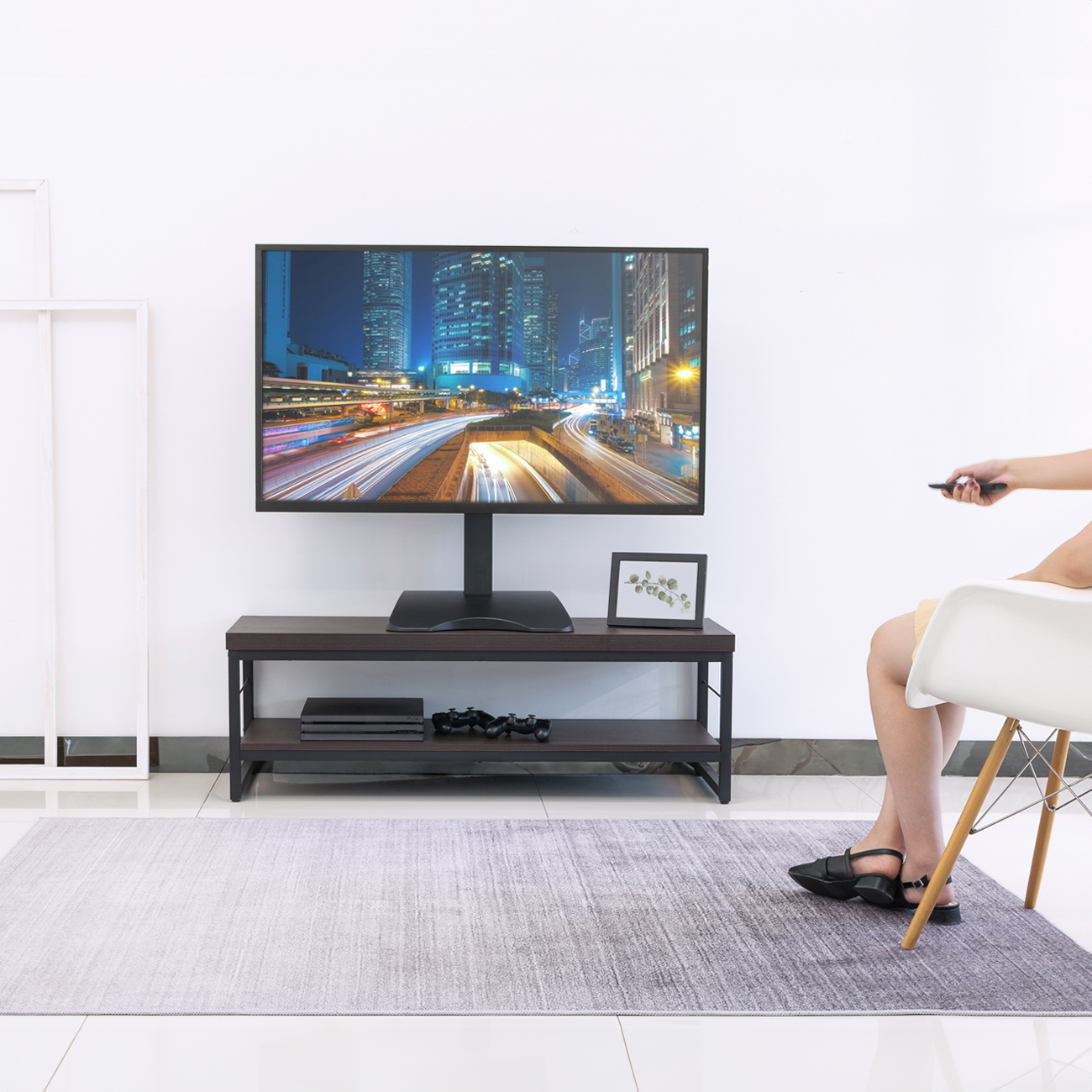 Ein Fernseher mit Ständer und Fernbedienung.
