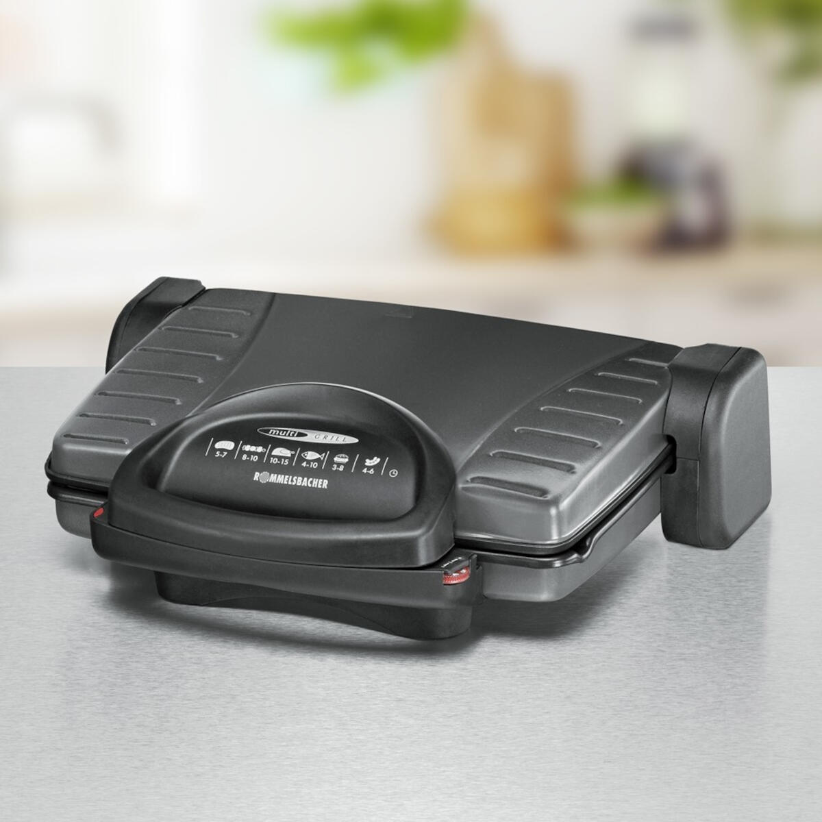 Czarny i srebrny grill wielofunkcyjny na jasnoszarej powierzchni.