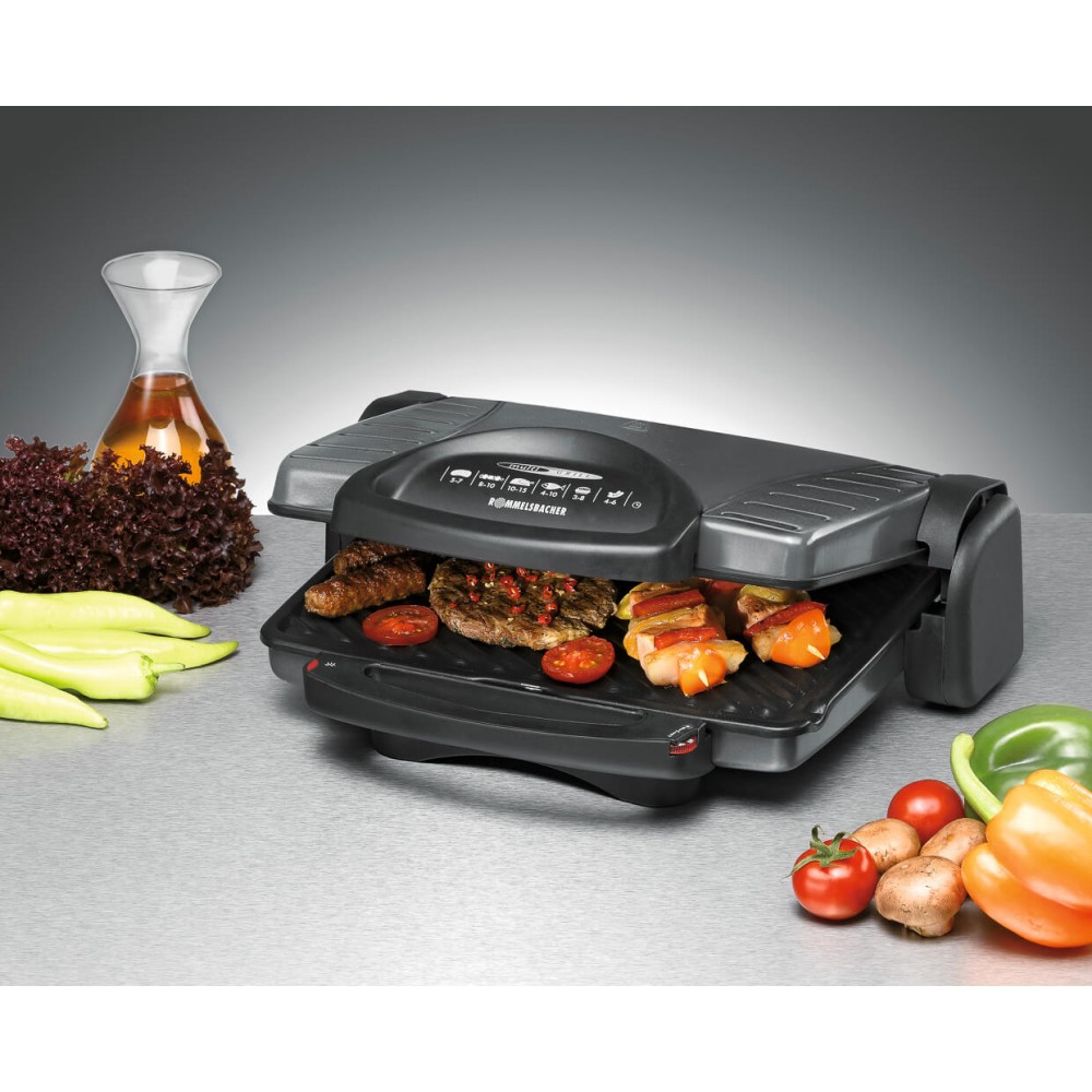 Grill z gotowanym jedzeniem i warzywami. Szklana butelka z płynem i sałatką po lewej.