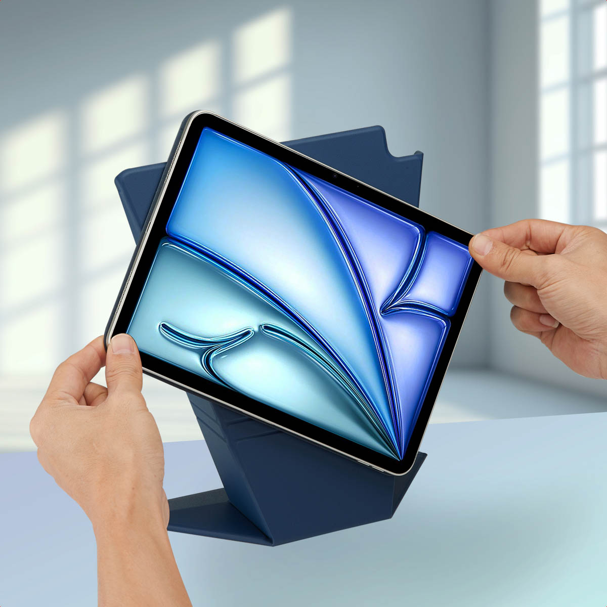 Hands holding a tablet in a dark blue stand. Blue screen.