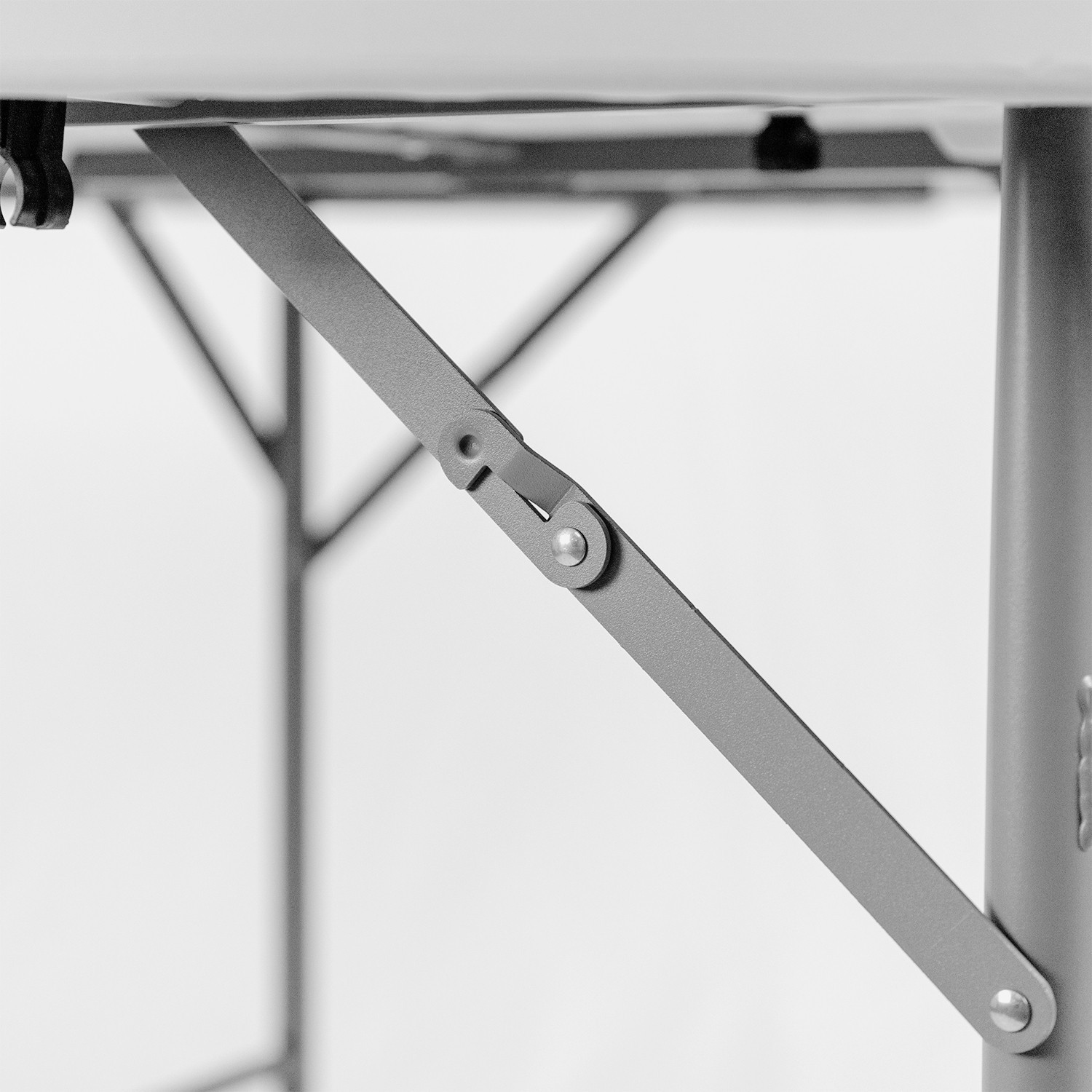 Primer plano de una articulación de pata de mesa con soporte gris metálico y fondo blanco.
