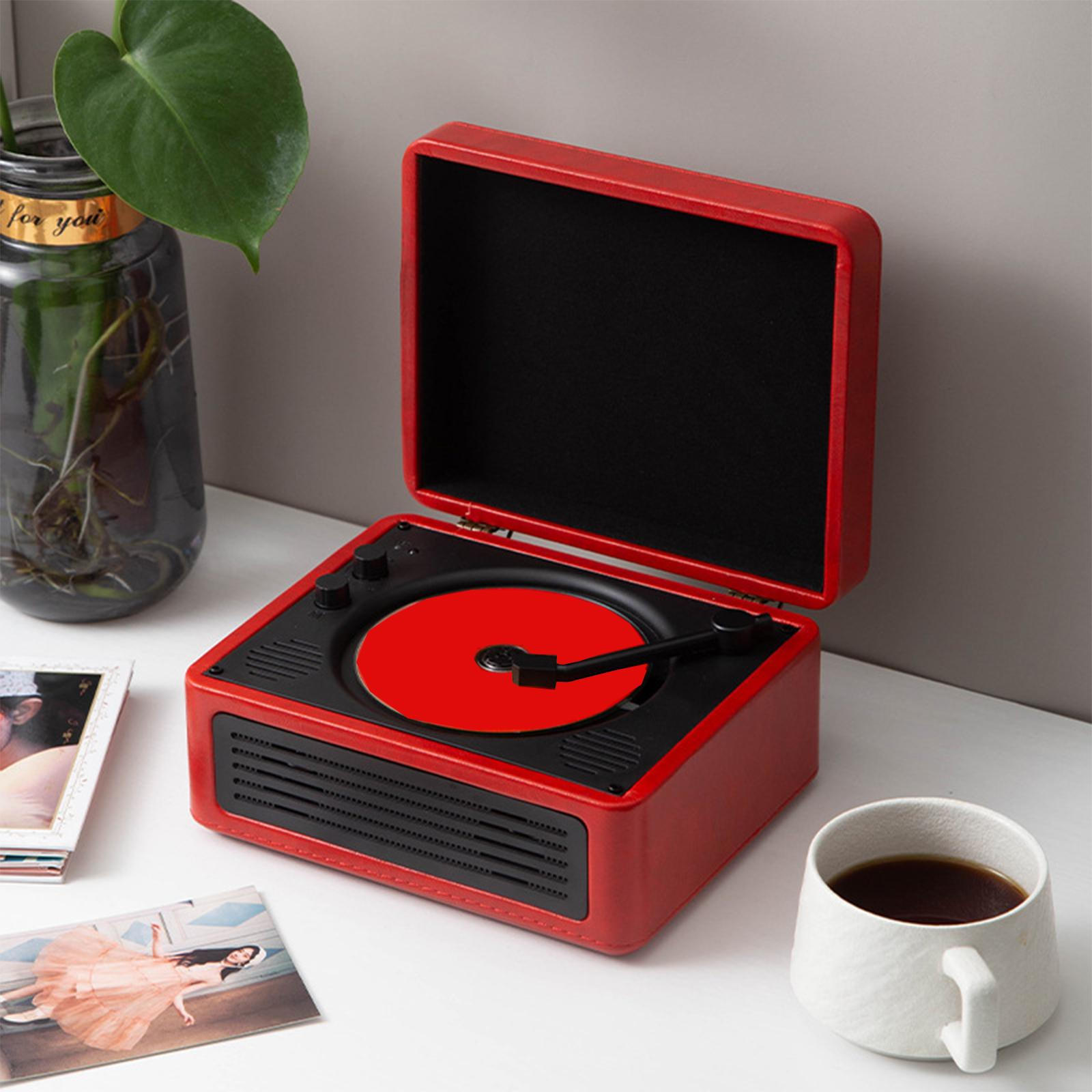 Roter Plattenspieler im Retro-Stil mit offenem Deckel, Schallplatte und einer Tasse Kaffee.