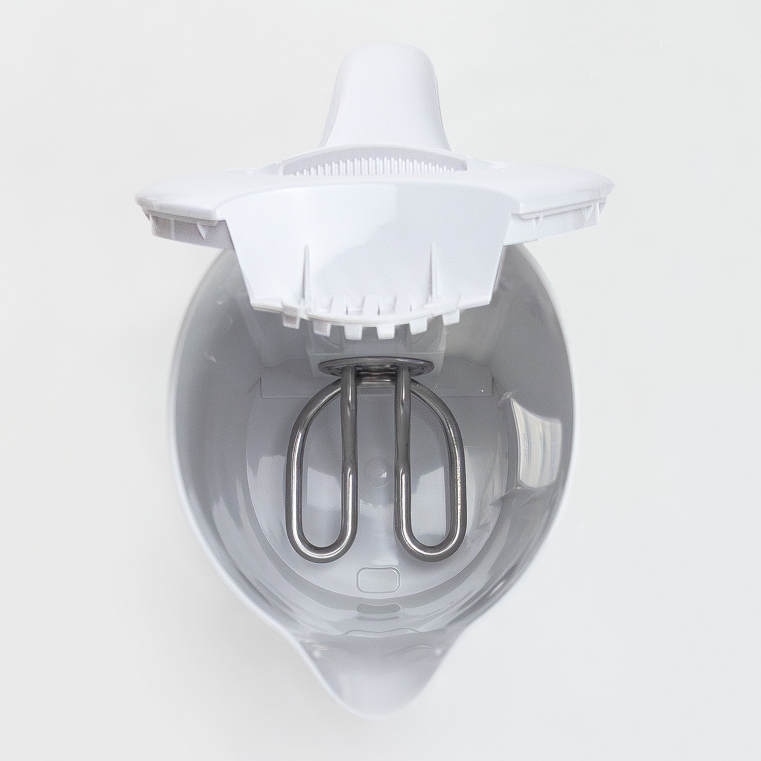 Interior de una tetera eléctrica blanca con un elemento calefactor.