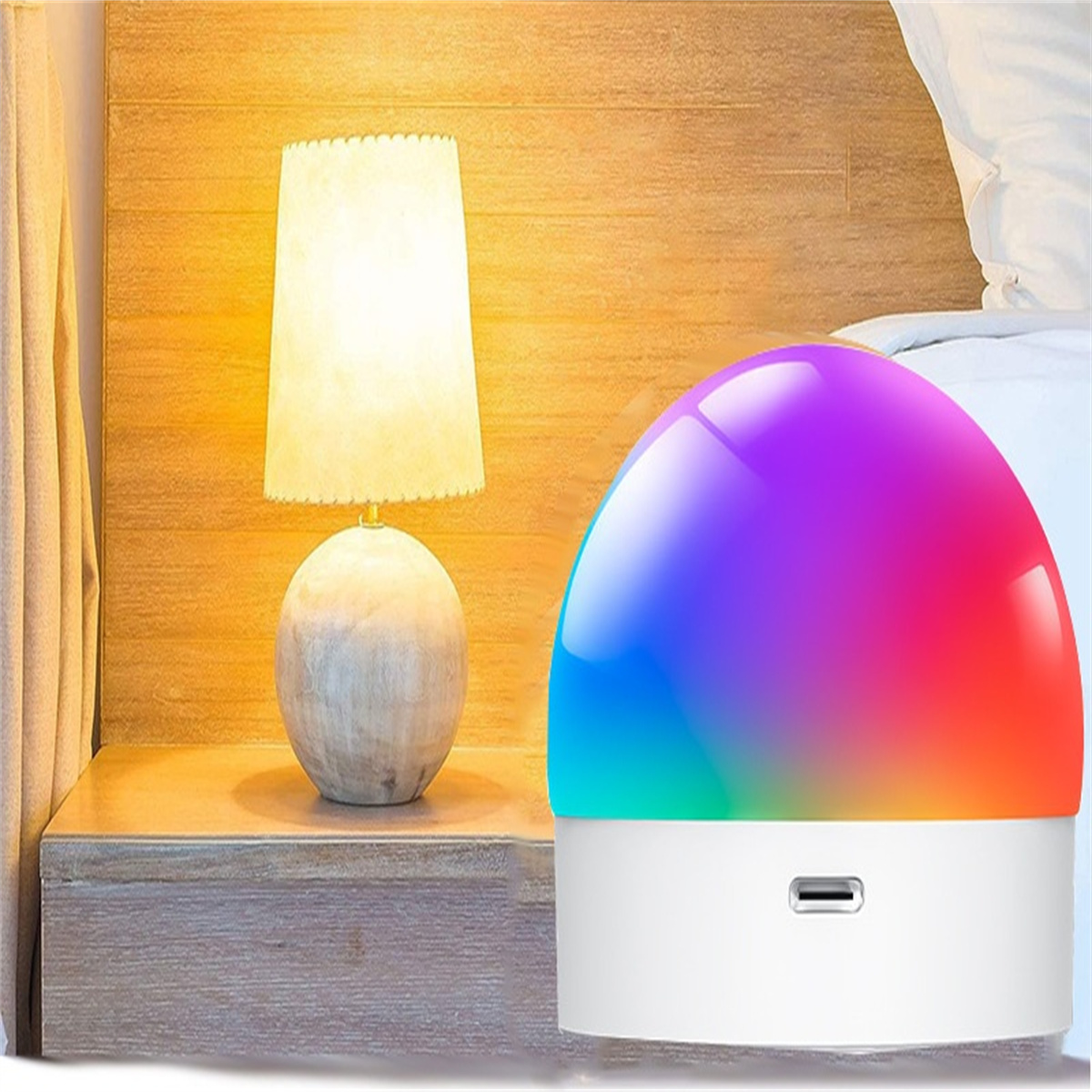 Eine Nachttischszene mit einer Tischlampe und einer intelligenten, farbwechselnden Lampe vor hellem Holz.