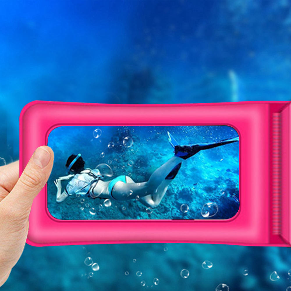 Eine Person hält eine pinke wasserdichte Handyhülle unter Wasser. Im Hintergrund schwimmt eine Person.