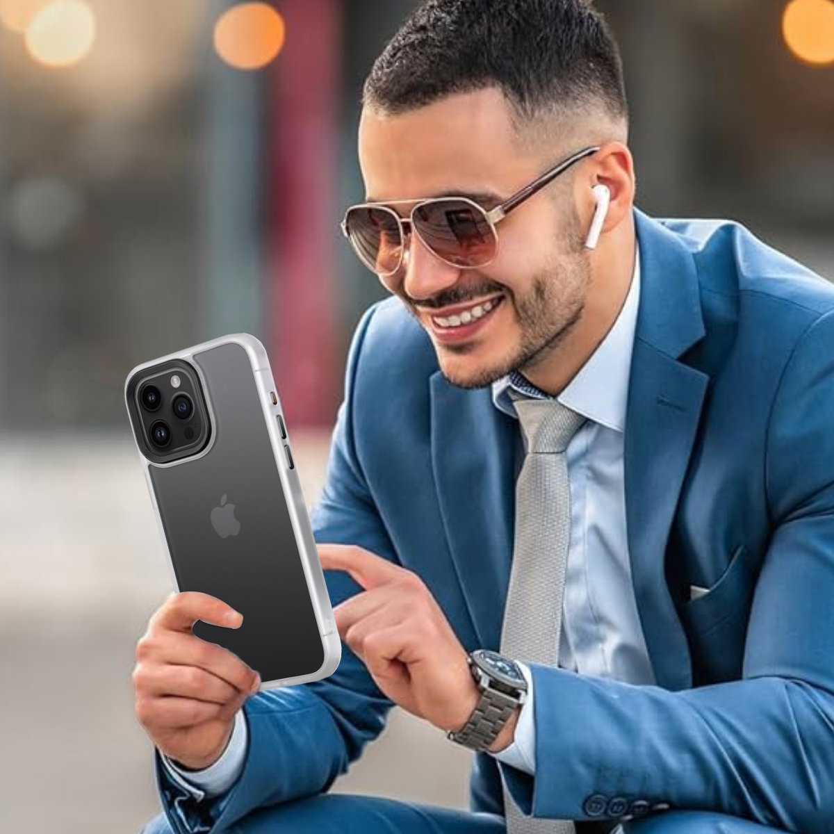 Mann in blauem Anzug hält Telefon mit klarer Hülle, lächelt mit Sonnenbrille und Ohrhörern.