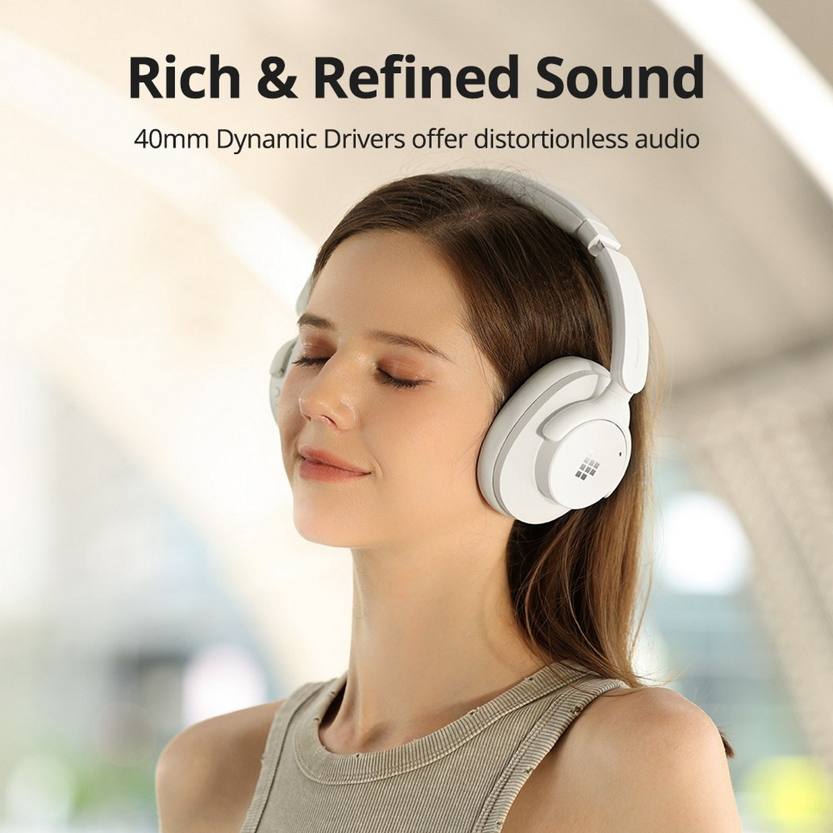 Mujer con auriculares blancos, ojos cerrados, sonriendo. Texto: Sonido rico y refinado.