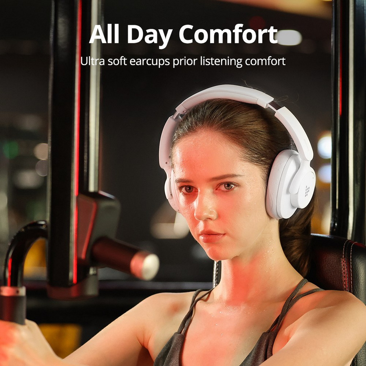 Mujer con auriculares blancos en un gimnasio, con el texto 'All Day Comfort'.
