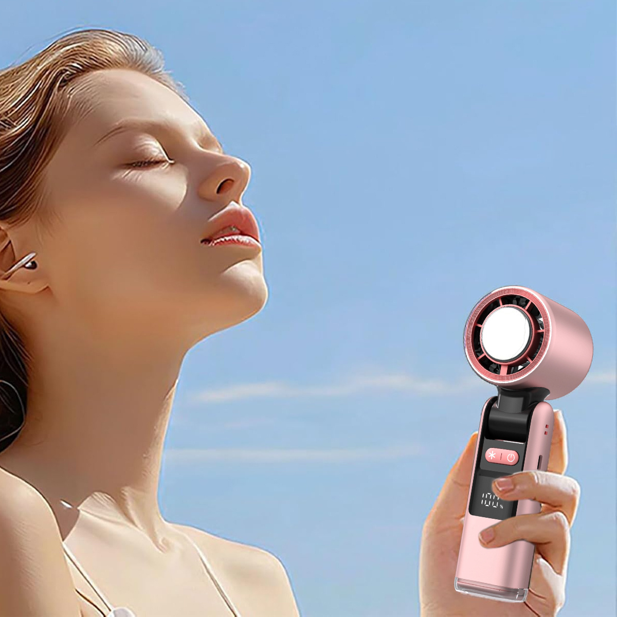 Frau mit pinkem Ventilator an einem sonnigen Tag, genießt die Brise.