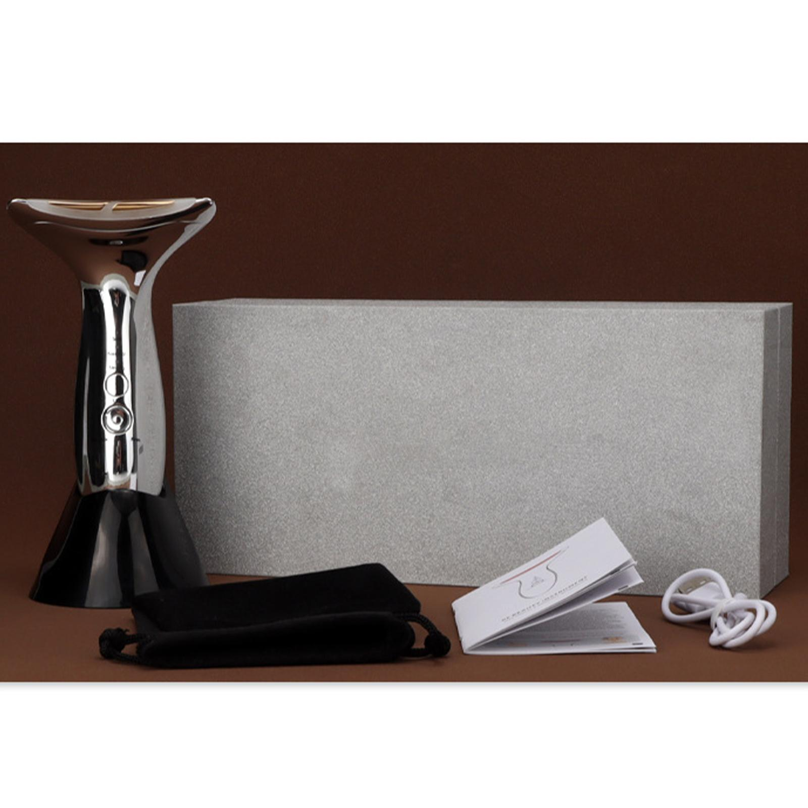 Ein silbernes und schwarzes Gesichtsmassagegerät mit Zubehör, Produktverpackung.