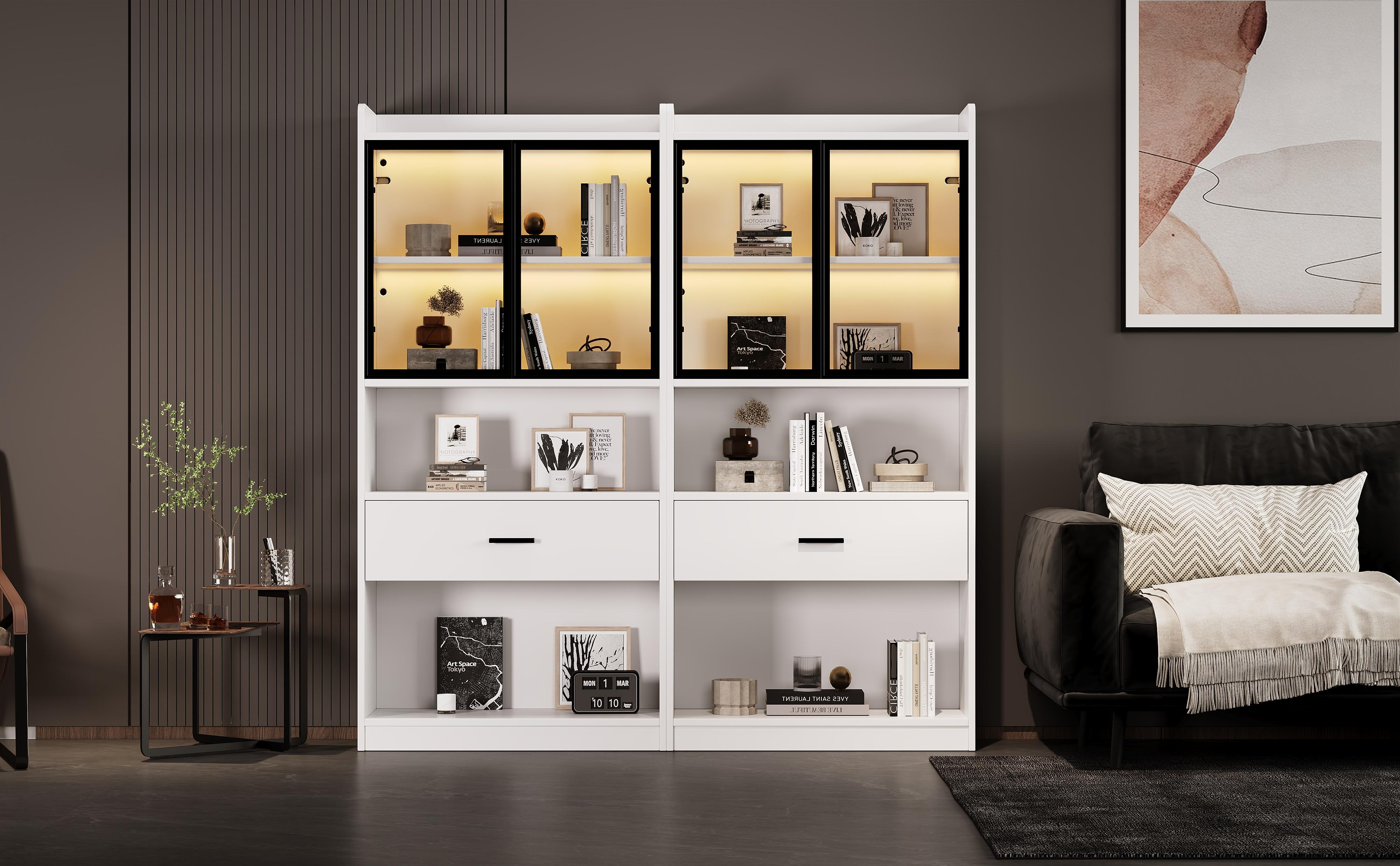 Ein weißes Bücherregal mit Glastüren und Schubladen. Bücher, Fotos und Dekorationen befinden sich darin.