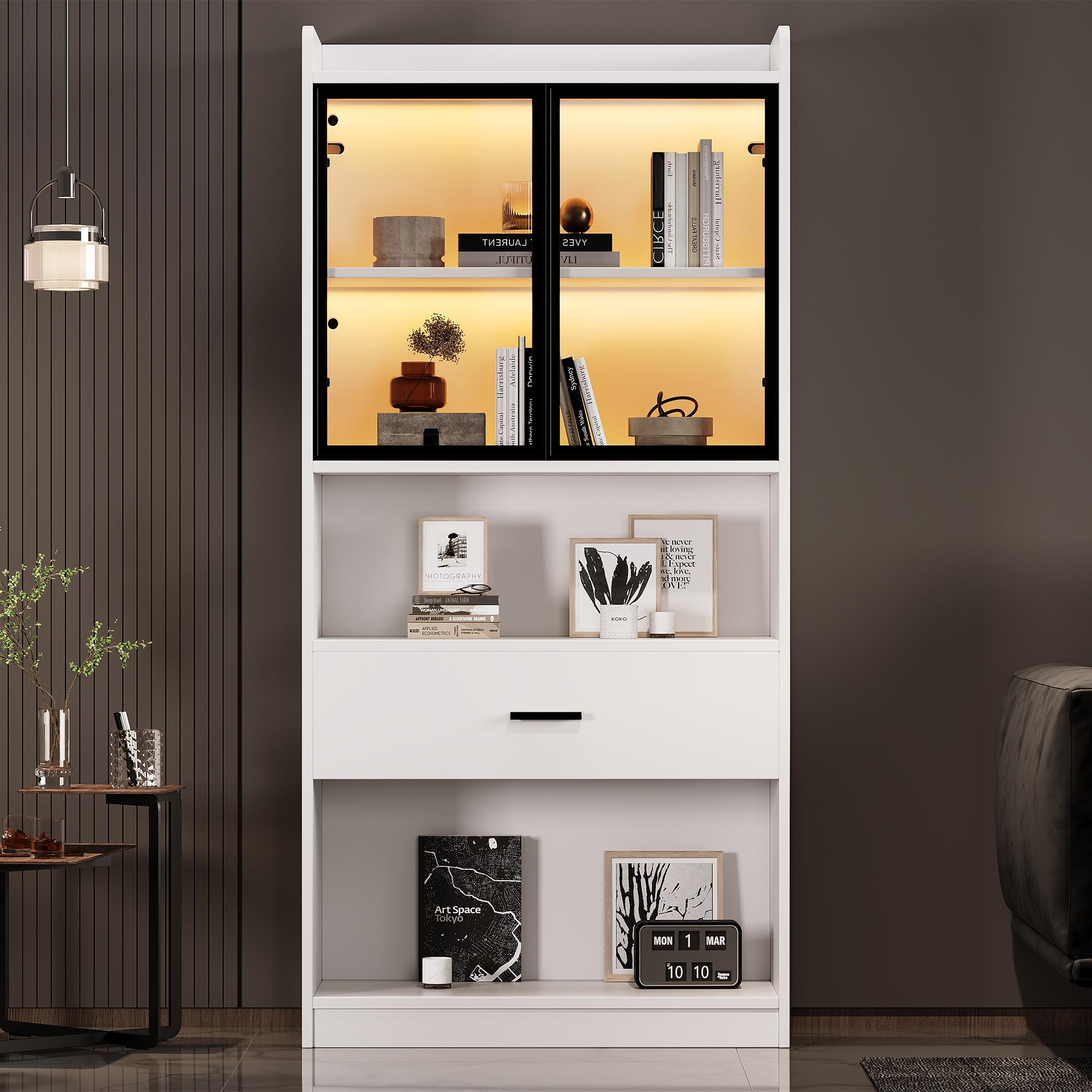 Weißer Schrank mit Glastüren und Regalen. Bücher und Dekorationen im Inneren. Eine Schublade und Bilder darunter.