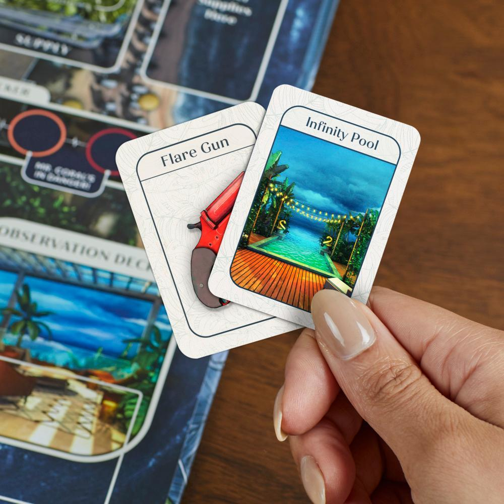 Spielkarten. Eine mit einer Waffe, die andere mit einer Poolszene. Beide liegen auf einem Spielbrett. Hand, die die Karten hält.