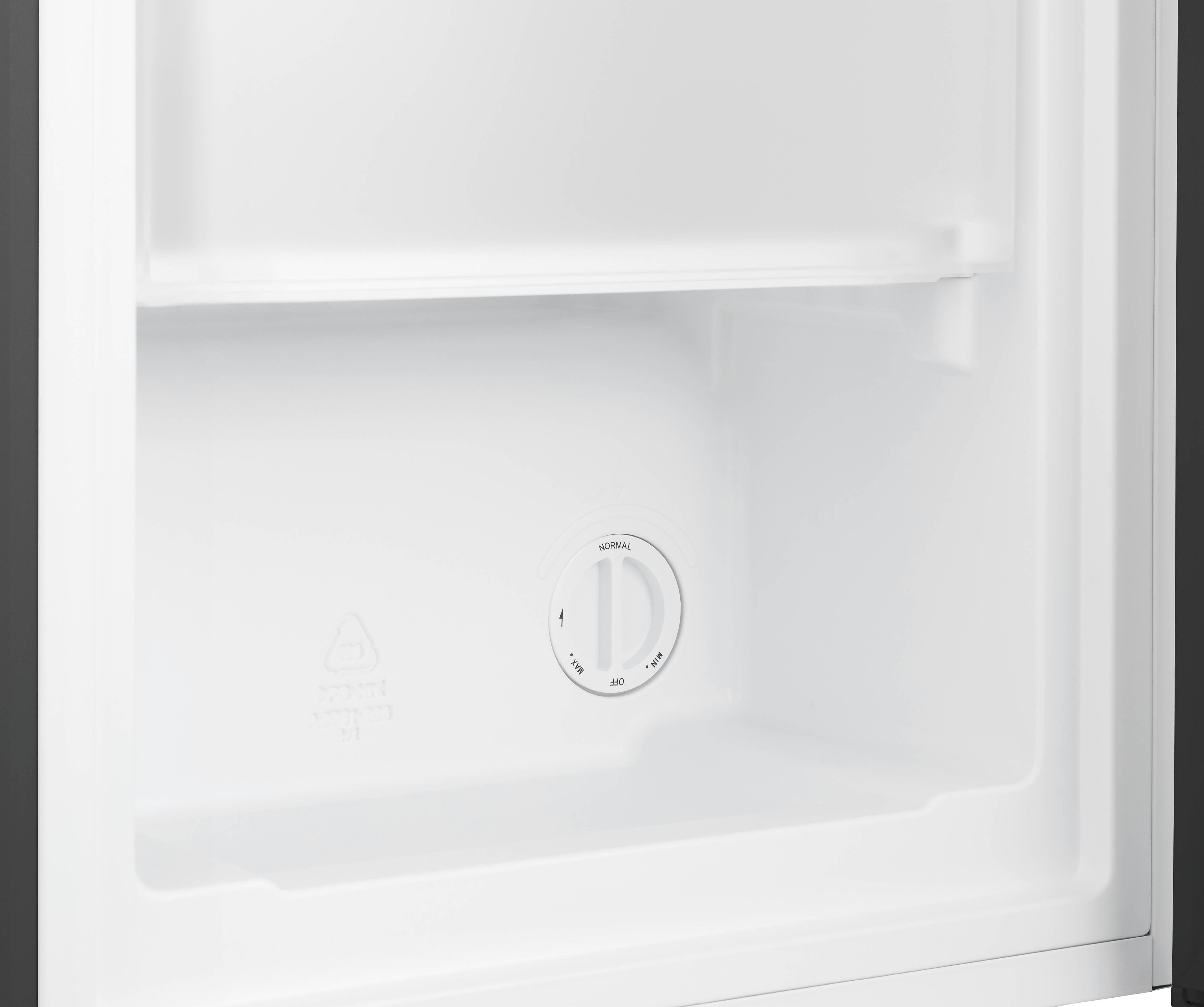 Inside of a refrigerator with a white interior. A circular dial with settings is visible.