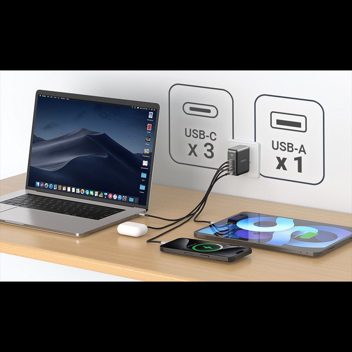 Laptop, adattatore, telefono e tablet su tavolo di legno.