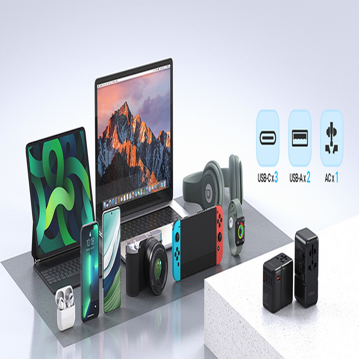 Eine Sammlung von technischen Geräten: Tablet, Telefon, Laptop, Kamera, Ohrhörer, Uhr und Ladegeräte.