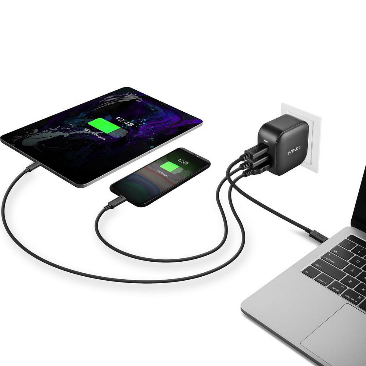 Un tablet e un telefono in carica con un caricatore da parete collegato a un laptop.
