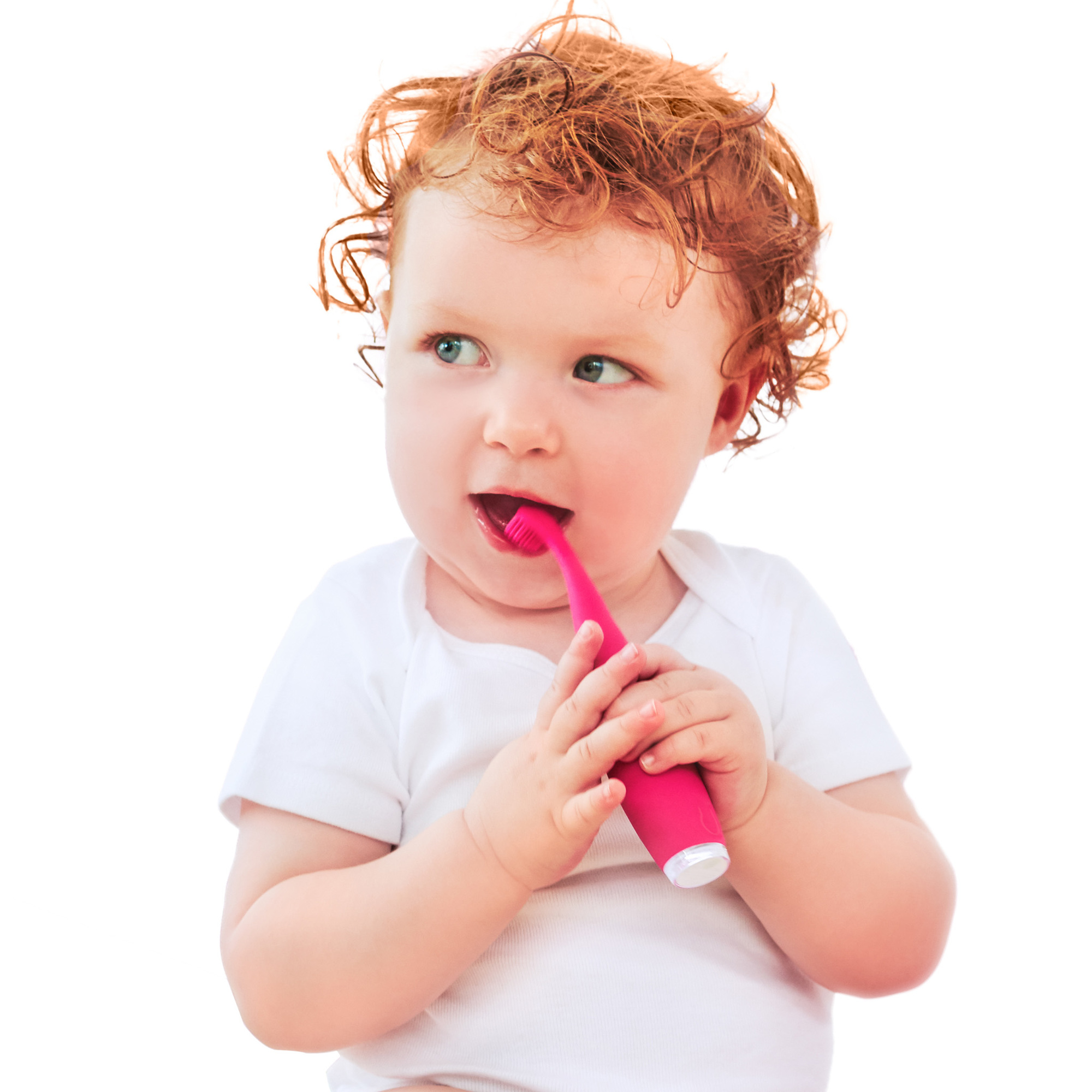 Un bebé pelirrojo sostiene un cepillo de dientes rosa, a punto de cepillarse los dientes.