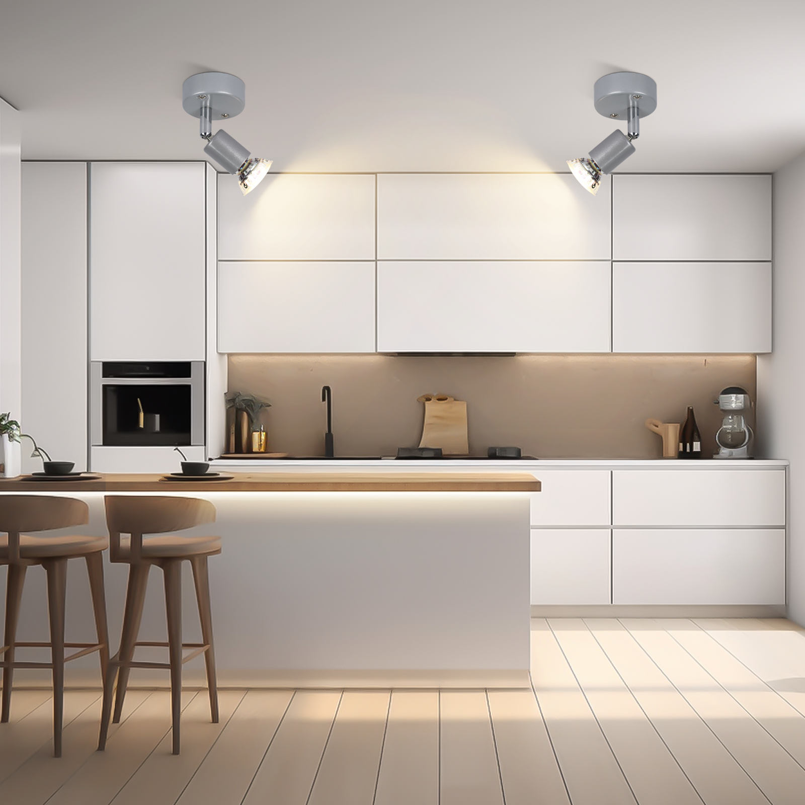 Nowoczesna kuchnia z białymi szafkami i dwoma reflektorami na suficie. Drewniane stołki barowe.