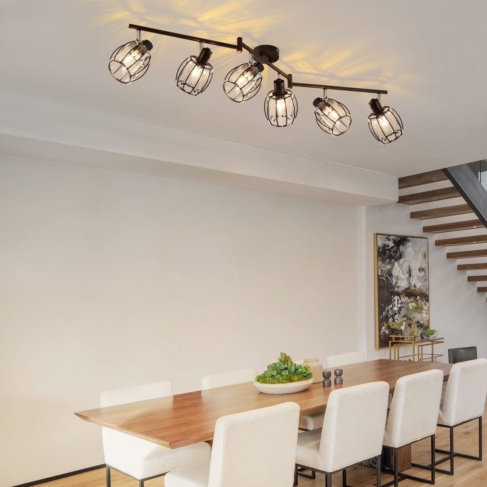 Długie, czarne oświetlenie szynowe z sześcioma kątowymi reflektorami w salonie.