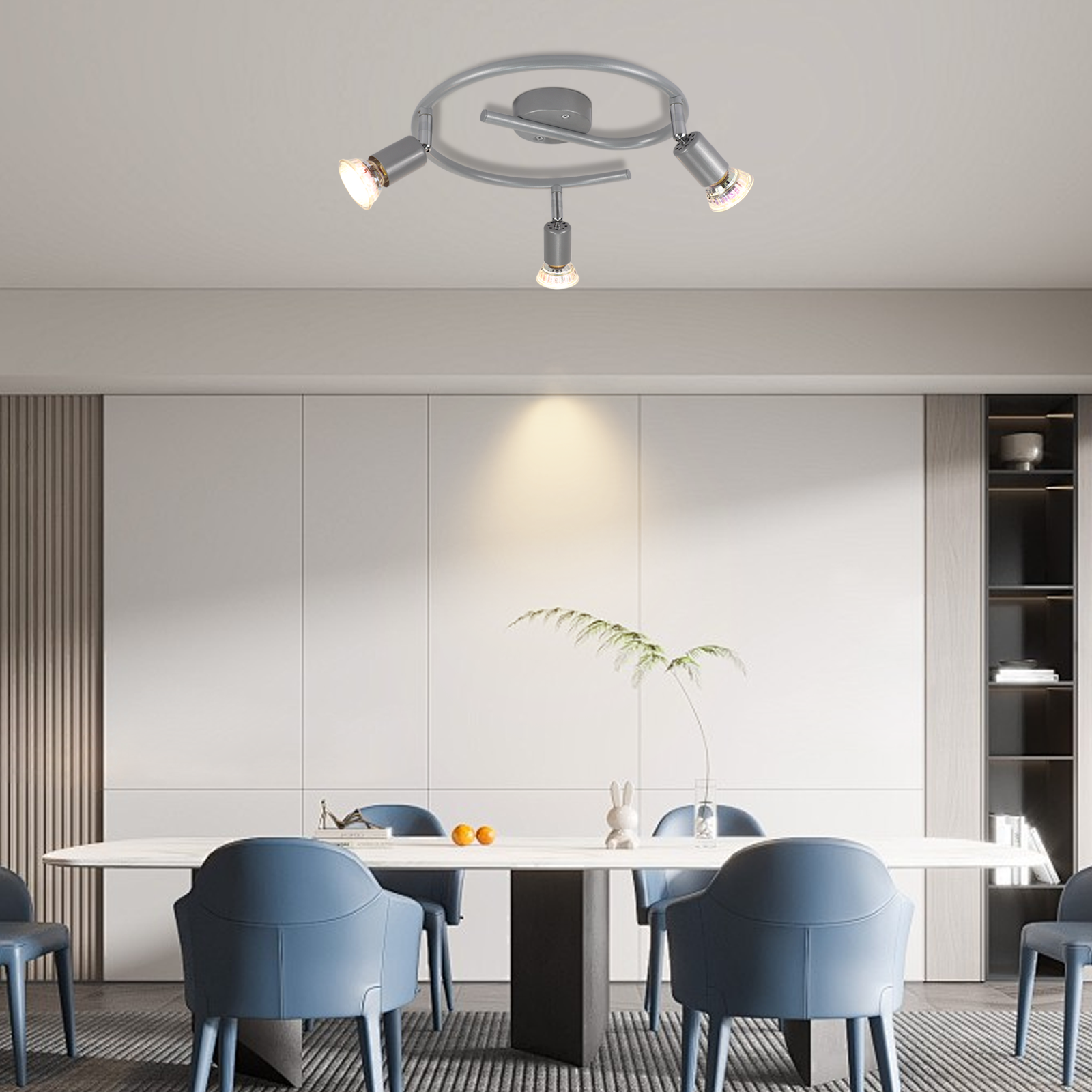 Jadalnia ze stołem, krzesłami i lampą sufitową z trzema reflektorami.