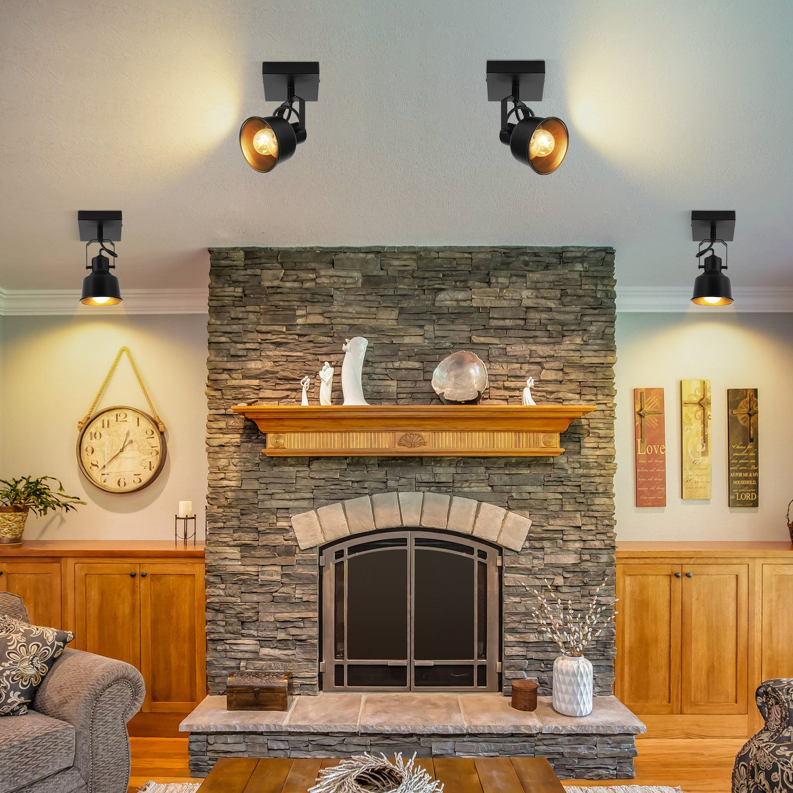 Salon z kamiennym kominkiem, trzema czarnymi lampami sufitowymi, drewnianymi szafkami i zegarem.