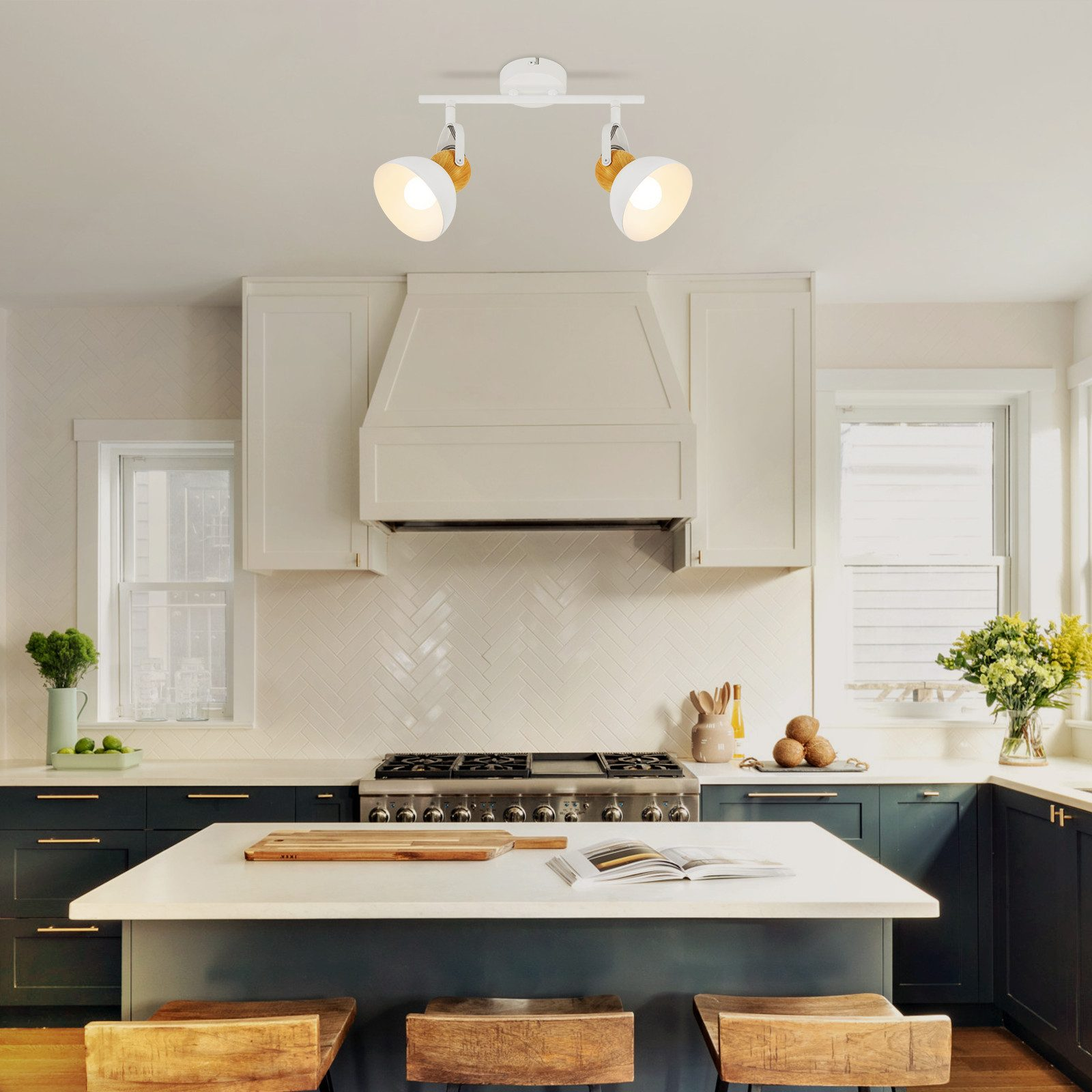 Kuchnia z oświetleniem szynowym, białą wyspą i kuchenką.