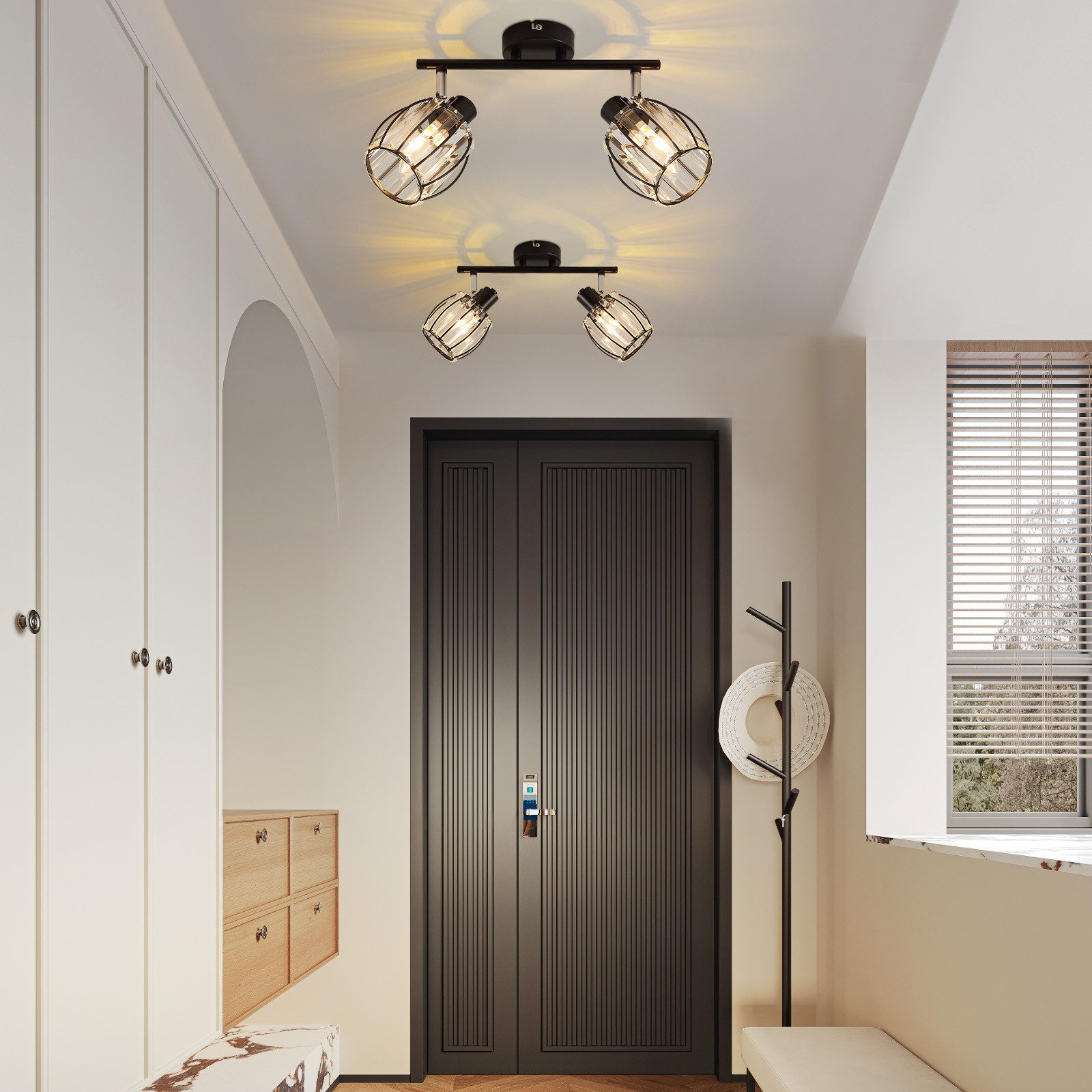 Korytarz z czterema reflektorami na suficie, oświetlającymi ciemne drzwi i wieszak na kapelusze. Białe ściany.