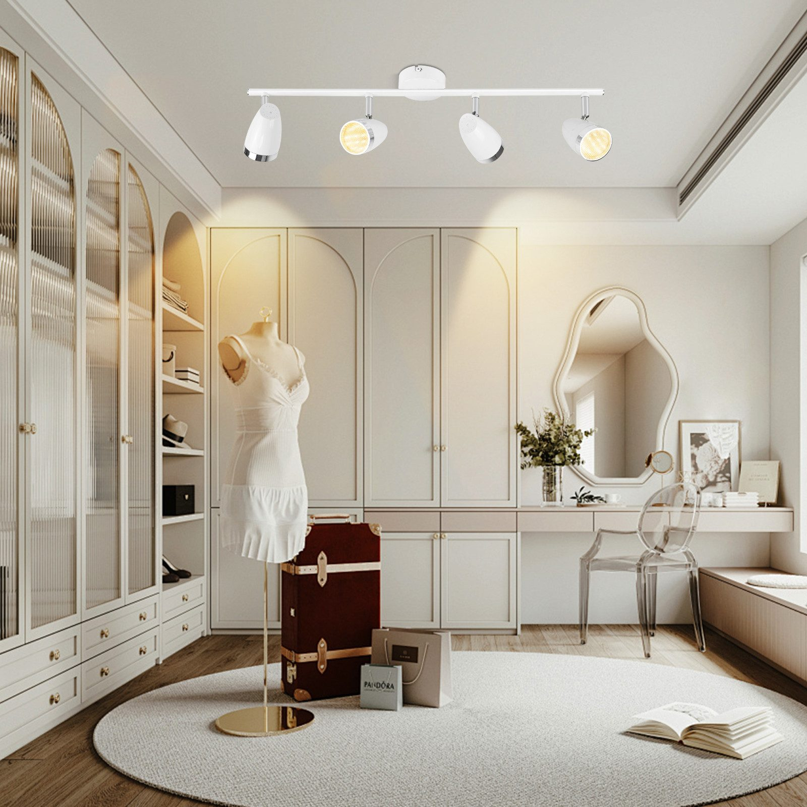 Ujęcie wnętrza pokoju z białą garderobą, manekinem, lustrem i szyną oświetleniową z reflektorami.
