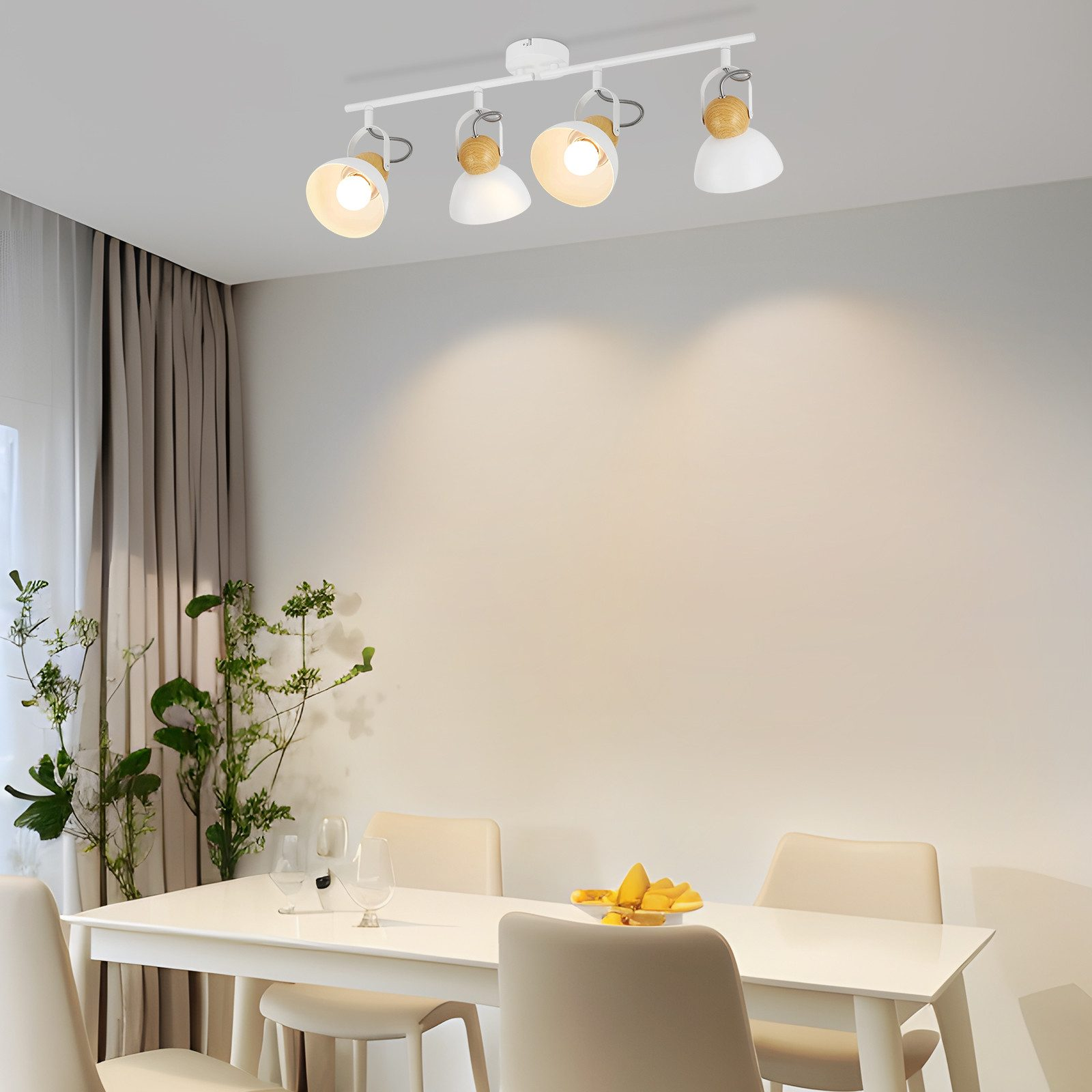 Biała lampa sufitowa z czterema reflektorami. Scena to jadalnia ze stołem i krzesłami.